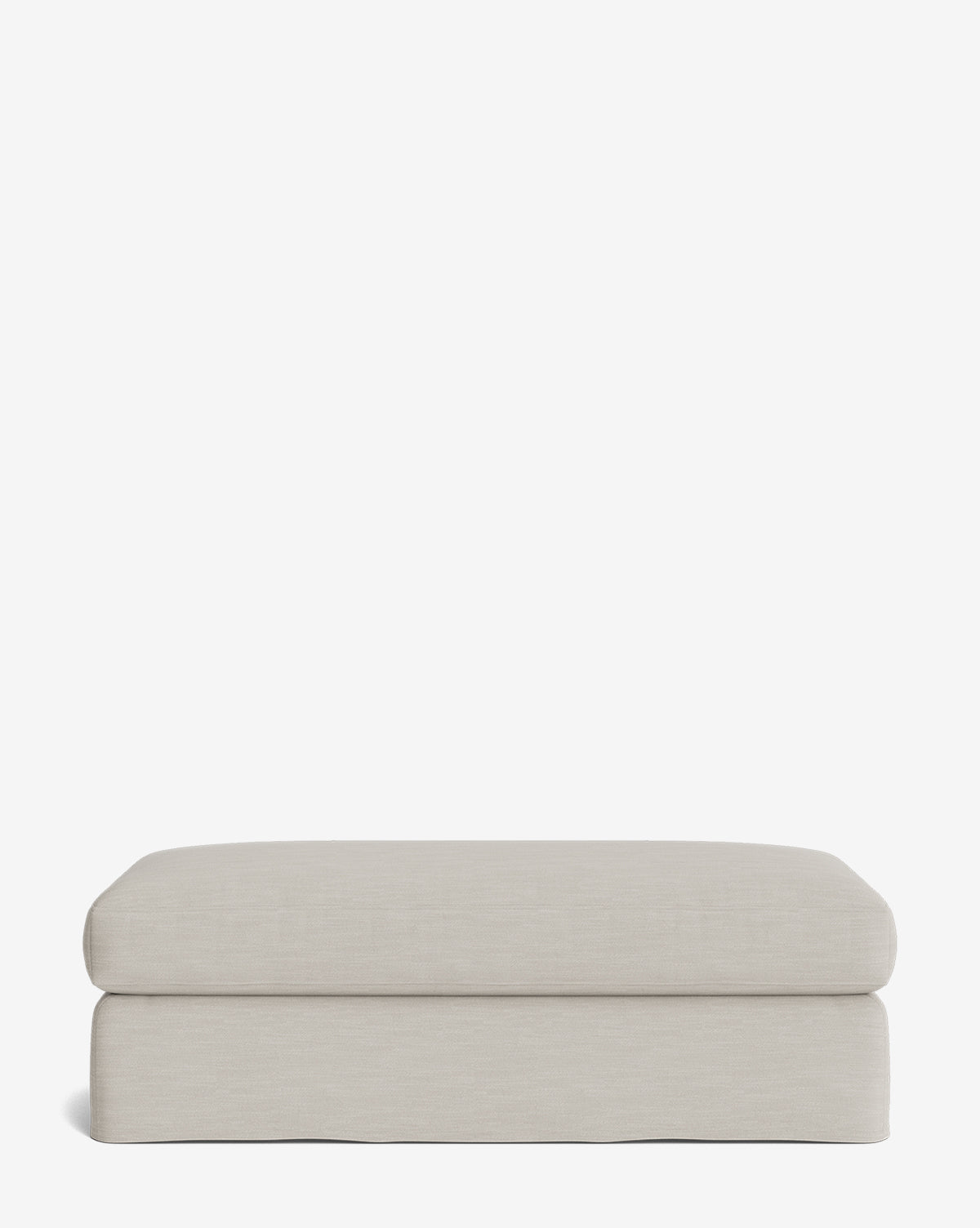 The Macy Slipcover Ottoman features a rectangular, light beige design with soft, rounded edges and a smooth surface—an inviting addition to your living room, shown against a plain white background, by McGee & Co.