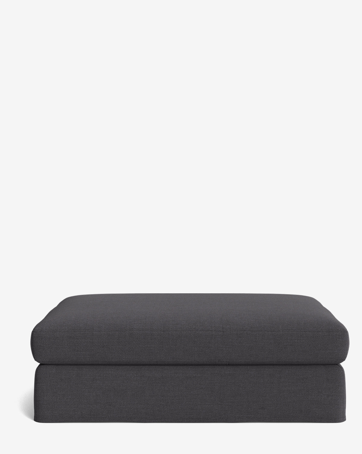 The Macy Slipcover Ottoman, shown in dark gray, sits against a plain white background. Its modern, simple design with clean lines and a soft cushioned top makes it a stylish, customizable choice for your living room, by McGee & Co.