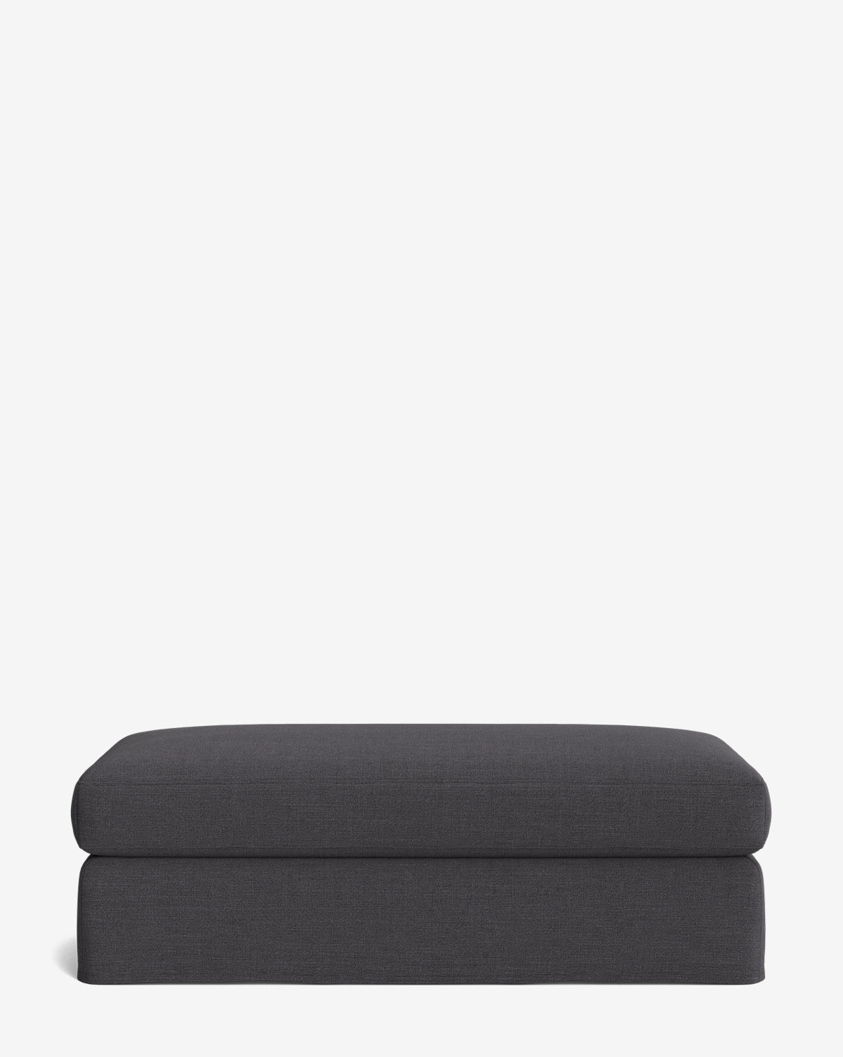 The Macy Slipcover Ottoman features a rectangular shape, dark gray upholstery, and clean, modern lines—an ideal customizable addition to your living room, shown here against a plain white background, by McGee & Co.