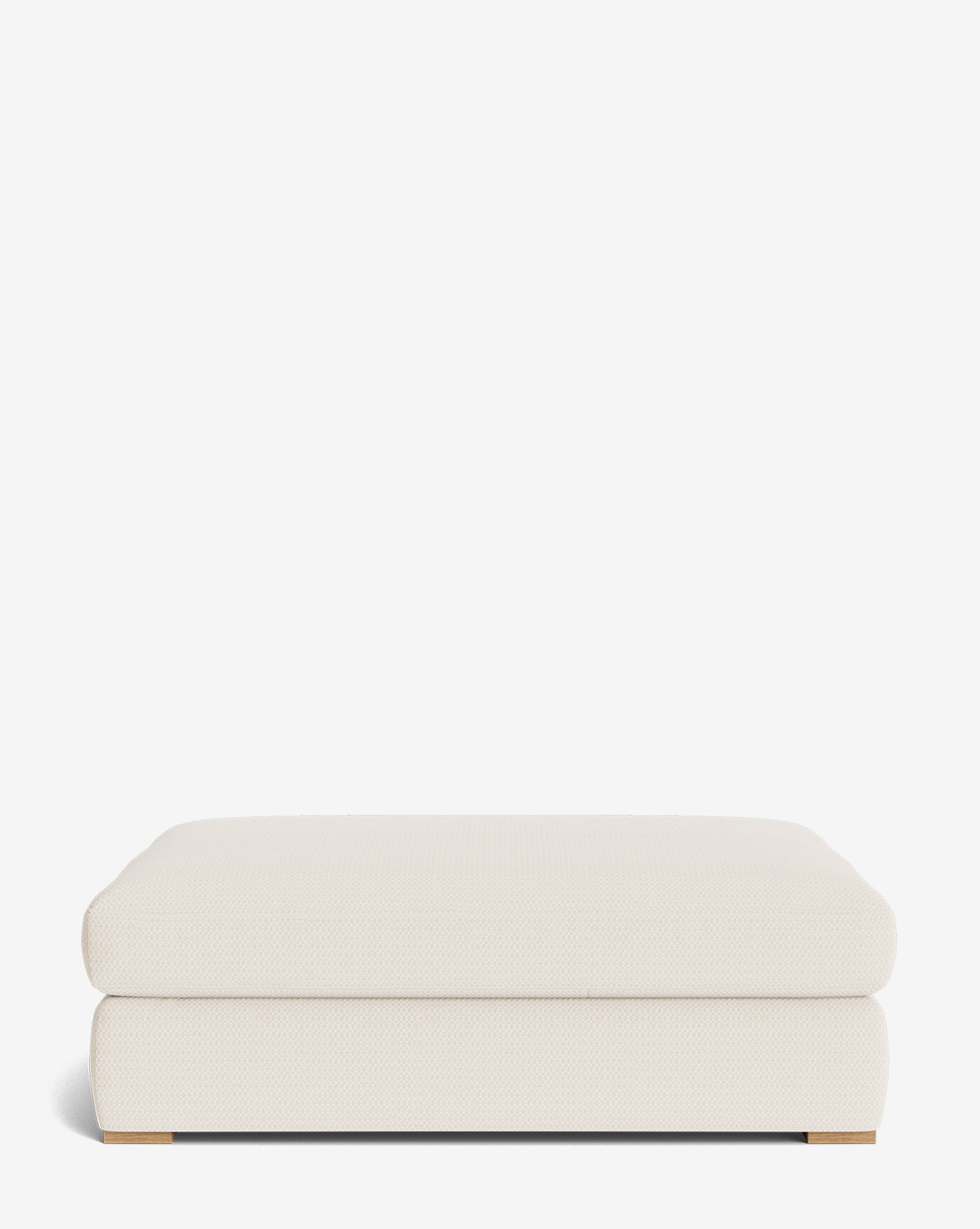 The Macy Upholstered Ottoman features a modern cream-colored design with rounded edges and low wooden feet, making it perfect for living room furniture, by McGee & Co. Shown against a plain white background.