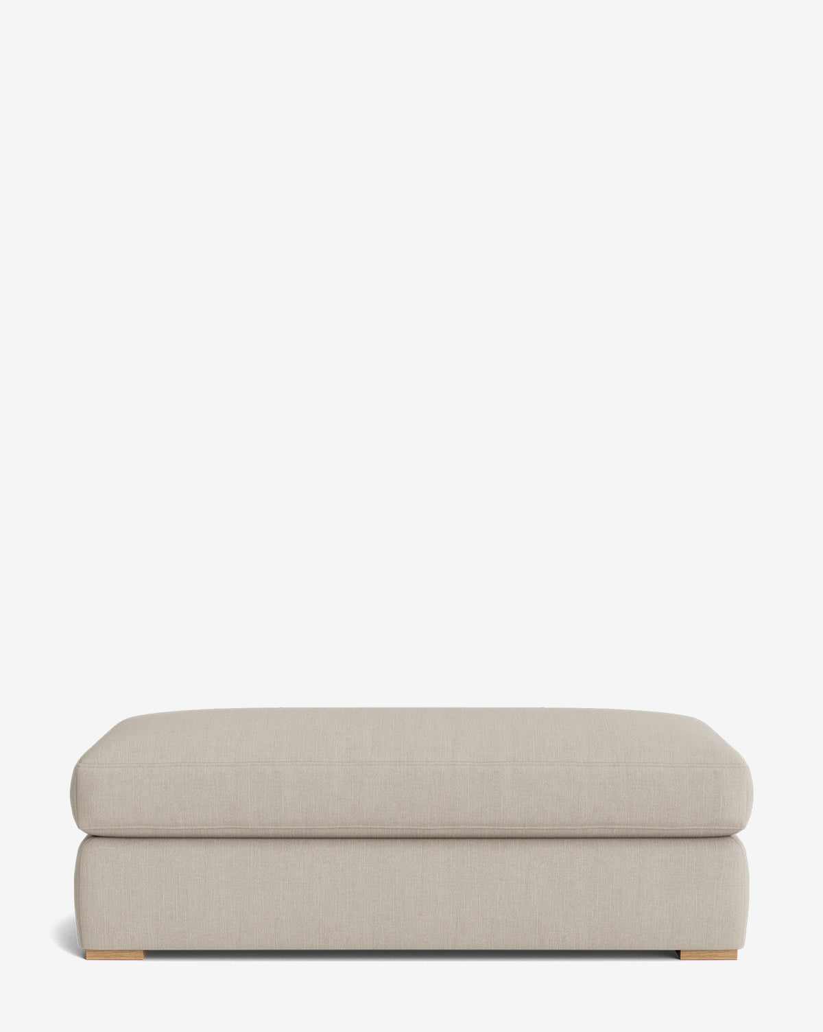 The Macy Upholstered Ottoman is a minimalist beige piece with a soft cushion, low profile, and small wooden feet—perfect for versatile living room use—displayed against a plain white background by McGee & Co.
