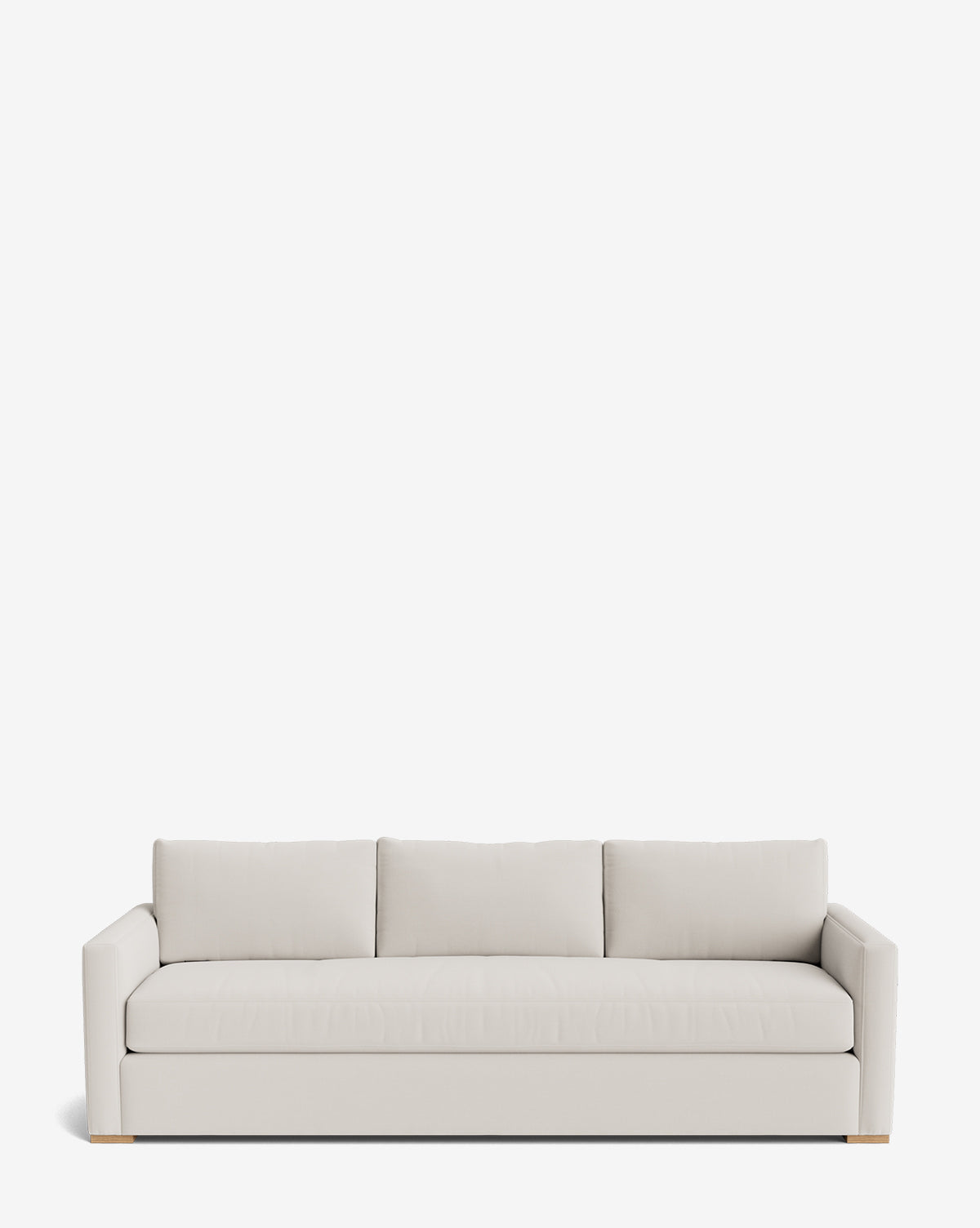 The Macy Upholstered Sofa (84-96) is a modern, light beige sofa with three seat and back cushions, clean straight arms, and wooden block feet. Its customizable, minimalist design makes it perfect living room furniture by McGee & Co.