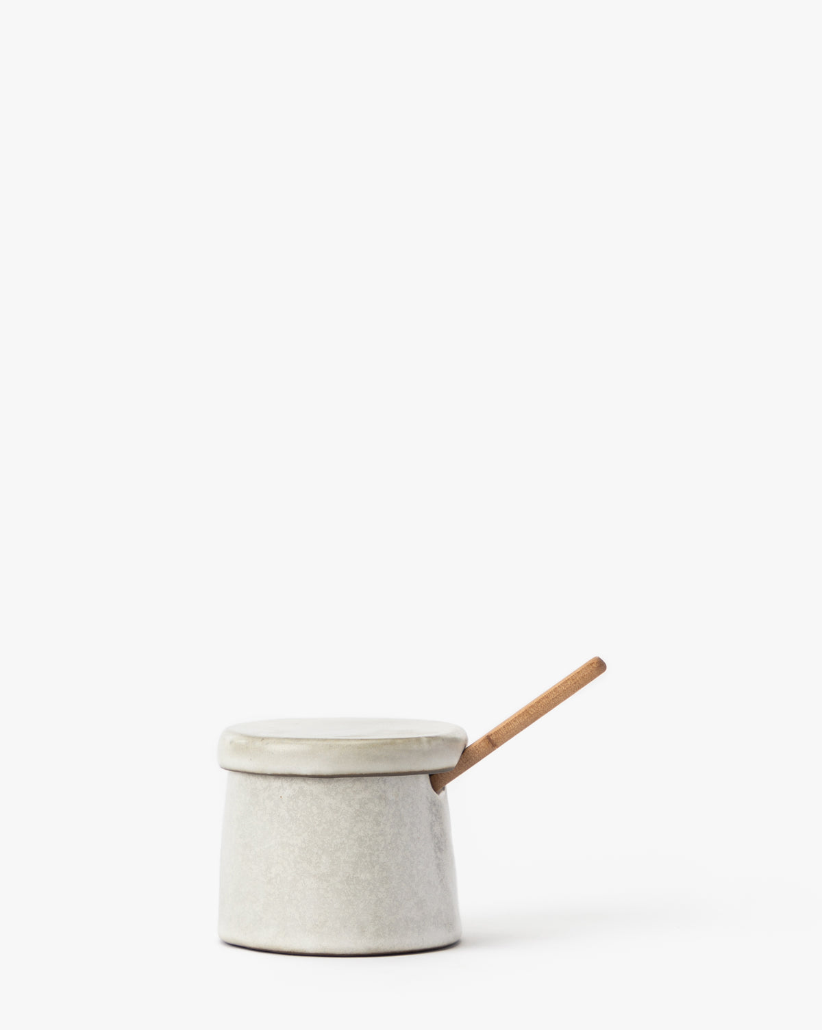The Malco Salt Cellar is a small ceramic jar with a matching lid and wooden spoon inside, displayed on a plain white background.