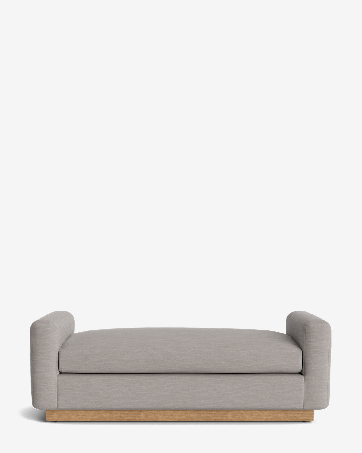 The Mansfield Bench is a modern bench featuring light gray upholstery, low rounded arms on each side, and a wooden base, by McGee & Co.