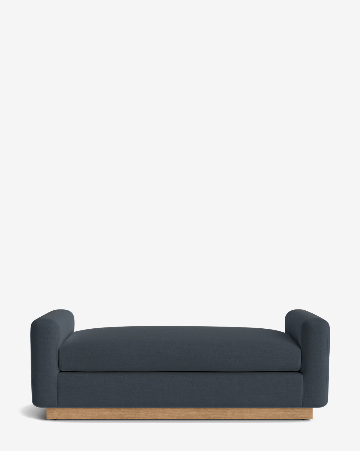 The Mansfield Bench is upholstered in dark blue with rounded arms and a low wooden base, shown against a plain white background, by McGee & Co.