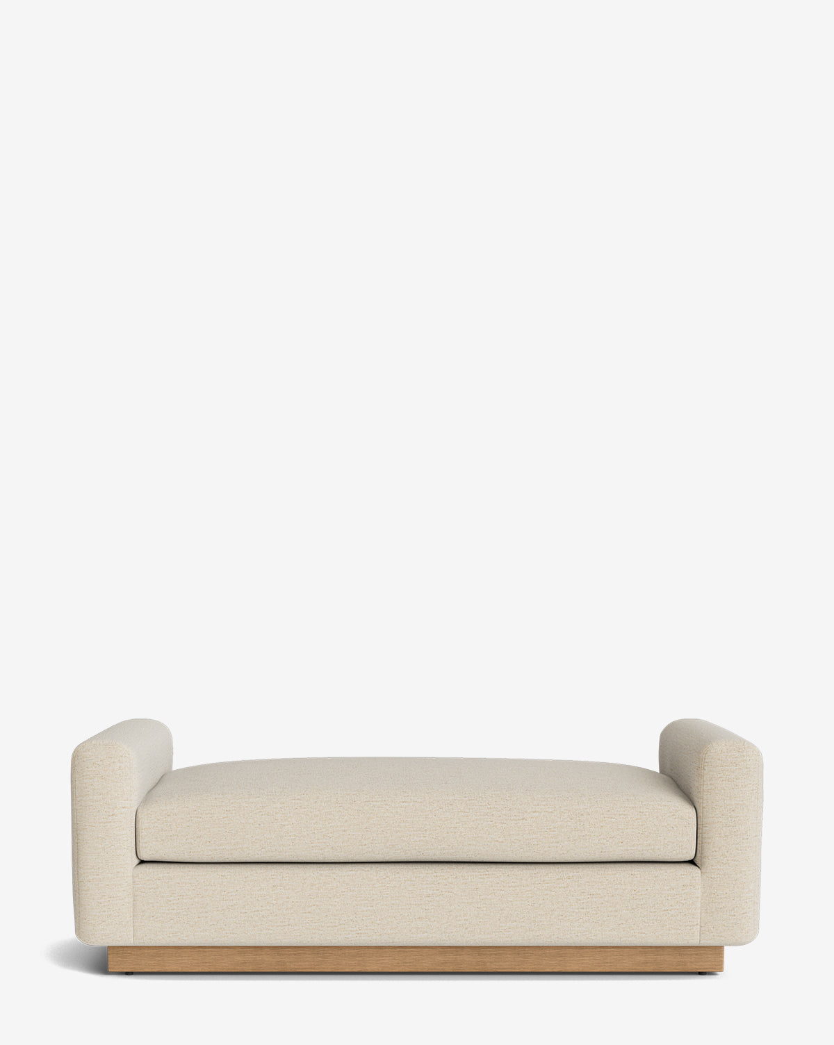 The Mansfield Bench is a modern bench in beige upholstery with thick, rounded armrests and a wooden base, shown against a plain white background by McGee & Co.