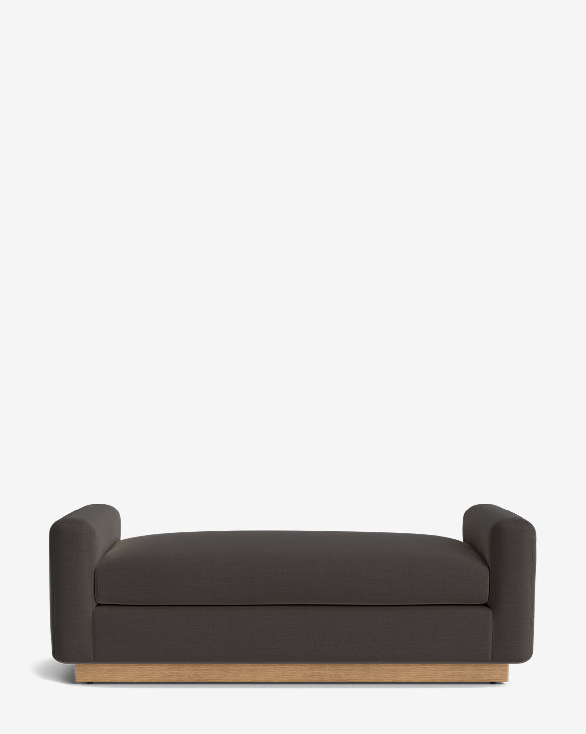 The Mansfield Bench features a modern, minimalist design with low armrests, dark gray upholstery, and a light wood base—its handcrafted look stands out against a white background, by McGee & Co.