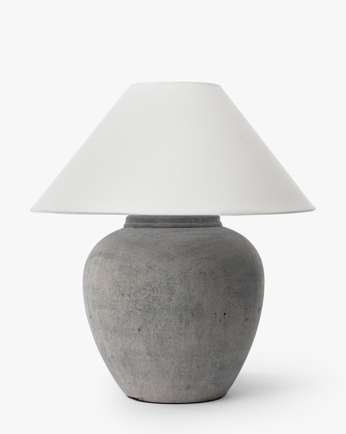 The Montague Table Lamp features a rounded, textured gray ceramic base and a wide, white conical shade, standing out against a plain white background by McGee & Co.