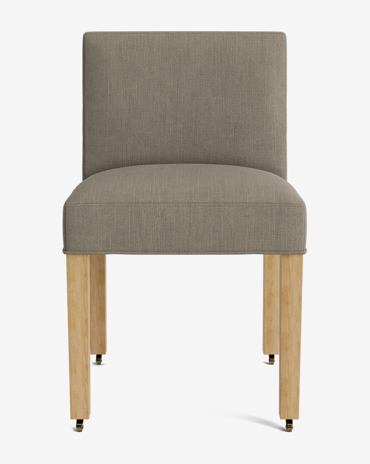 The Olivier Upholstered Dining Chair features a light brown feather and down blend seat and backrest, set on four light wood legs with black and brass casters, shown against a plain white background by McGee & Co.