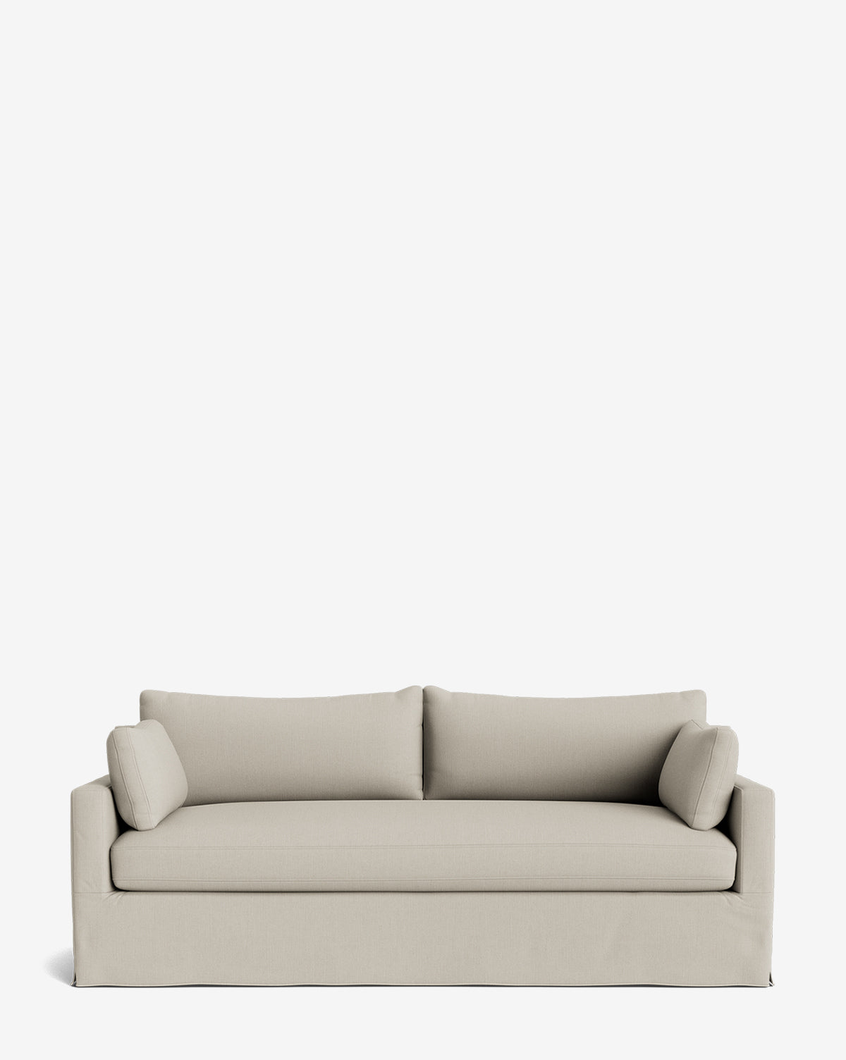 A modern Peterson Classic Slipcover Sofa (75-100) in light beige, featuring a boxy design, feather blend cushions, and two cylindrical side pillows, is displayed against a plain white background by McGee & Co.