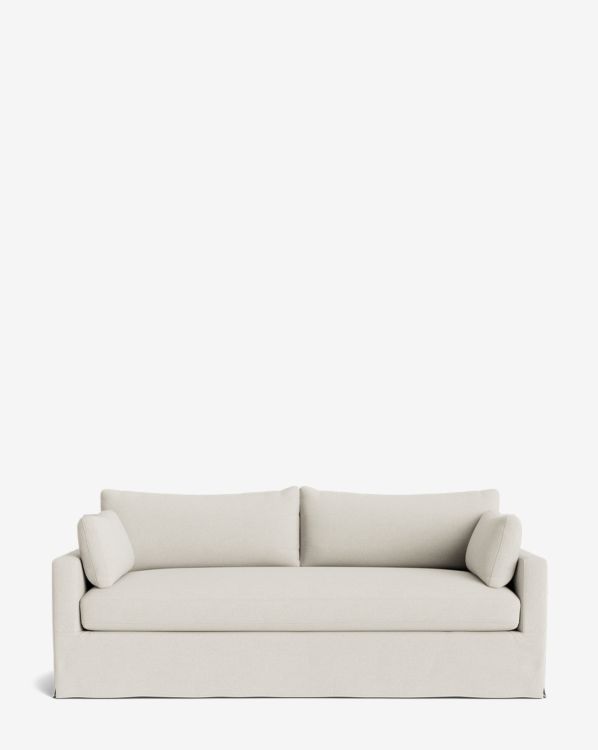 A Peterson Classic Slipcover Sofa (75-100) in light beige with clean lines, two seat cushions, feather blend fill, and matching bolster pillows is shown against a plain white background by McGee & Co.