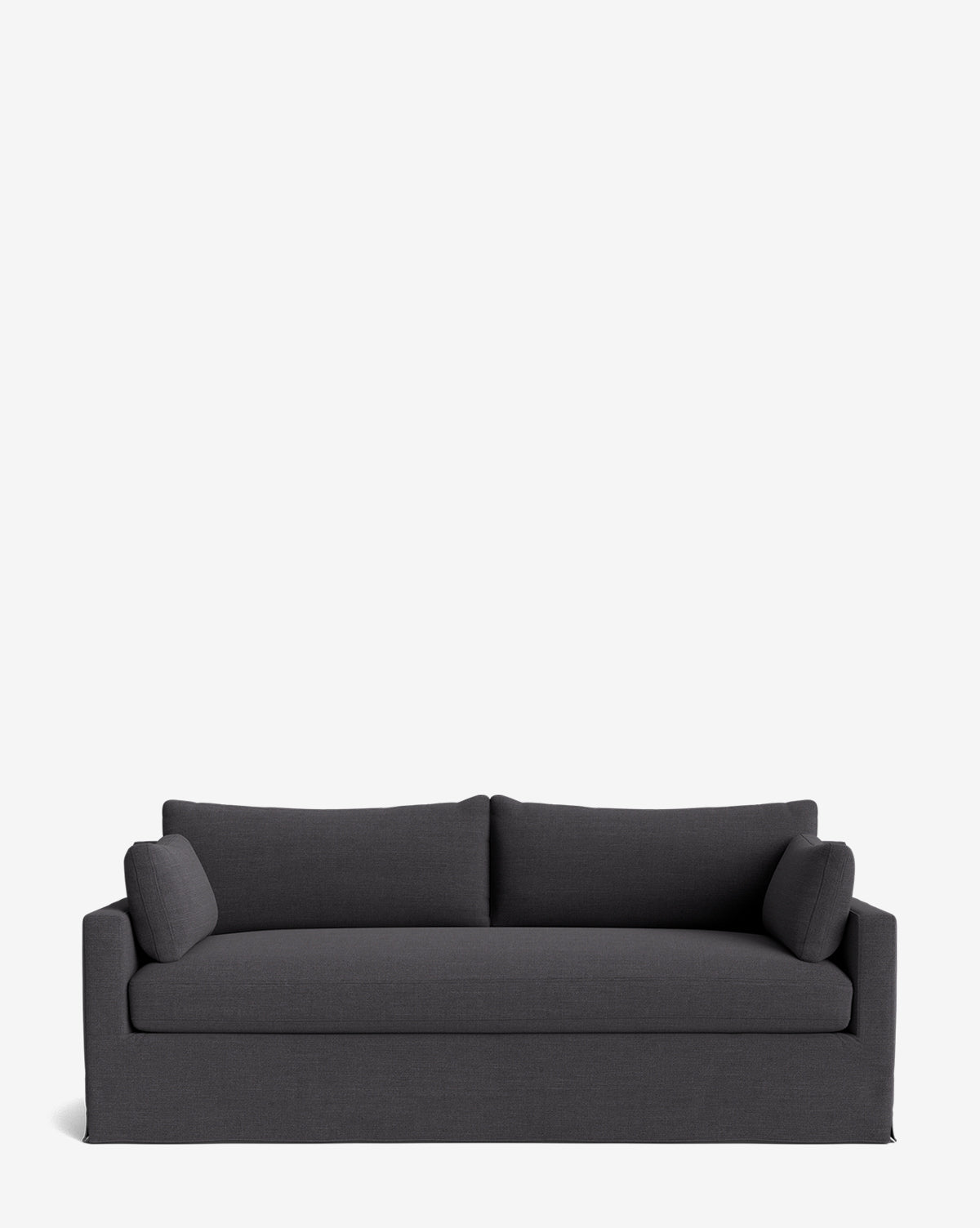 A modern dark gray Peterson Classic Slipcover Sofa (75-100) with two feather blend cushions and two bolster pillows, shown against a plain white background. The sofa features clean lines and a simple, contemporary design, by McGee & Co.