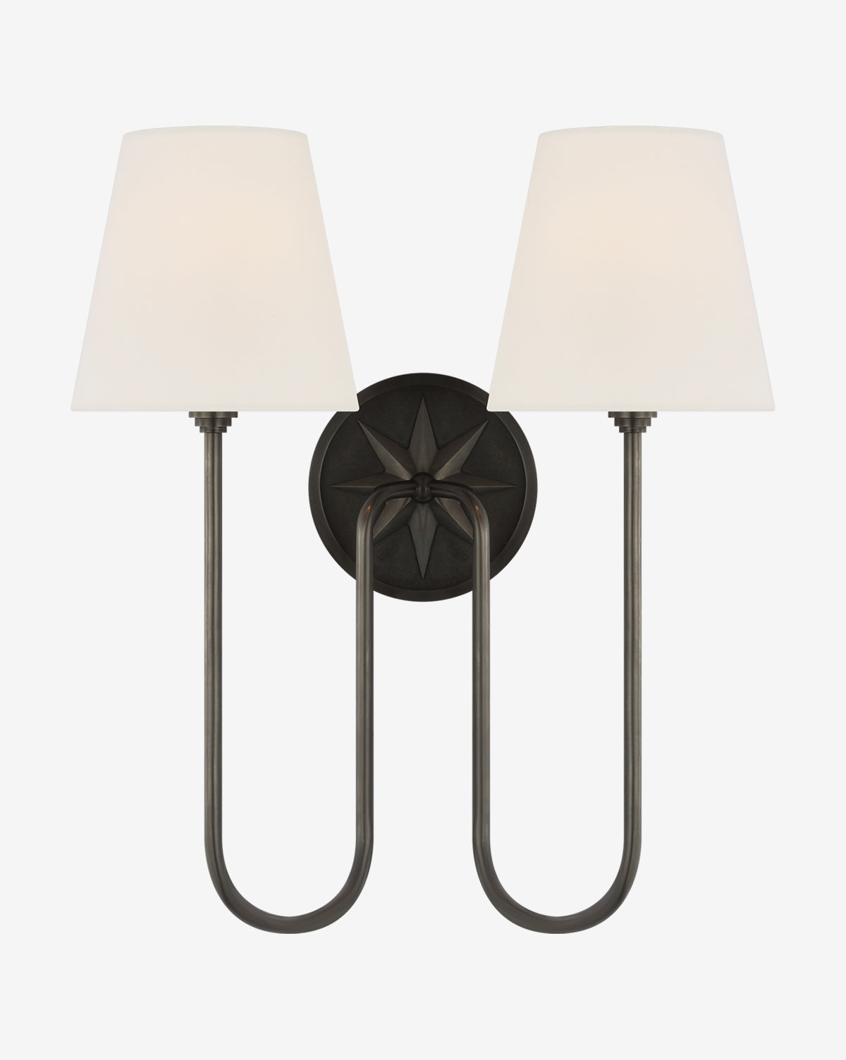 The Polaris Double Sconce by Visual Comfort & Co. Signature adds classic elegance with swooped arms, tapered white linen shades, and a dark circular base featuring a striking starburst design. Wall-mounted for sophisticated style in any space by McGee & Co.