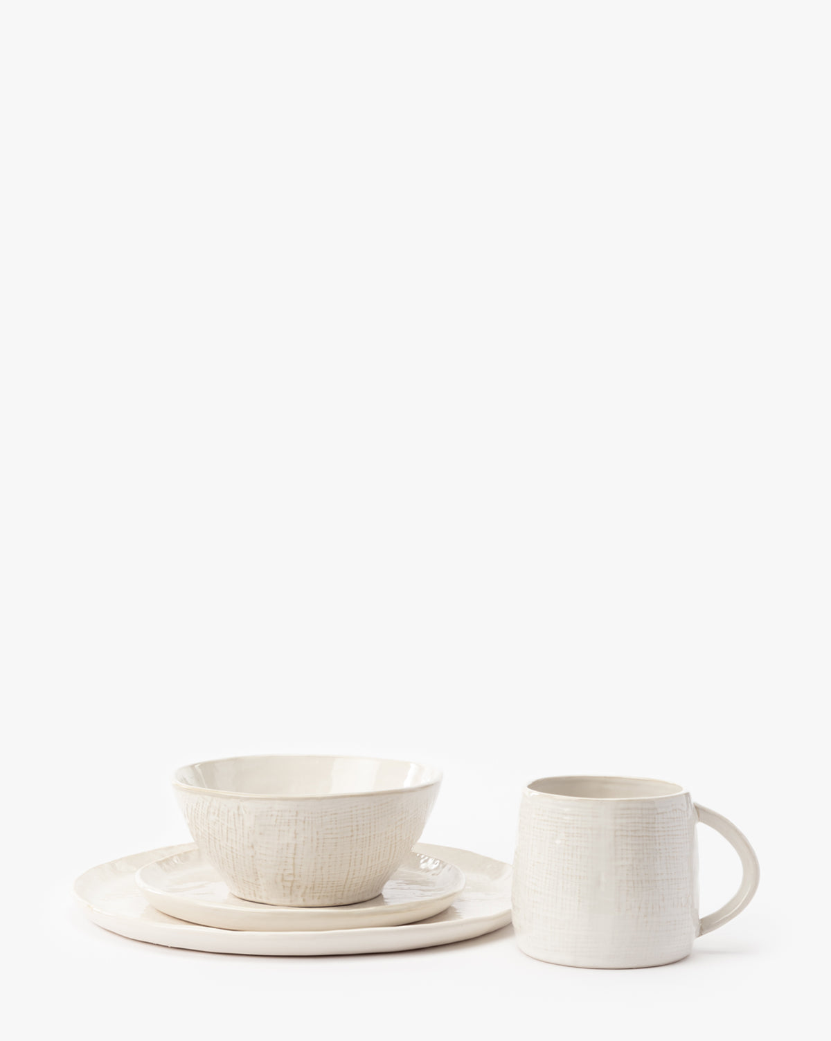 A set of four Radlee Dinner Plates, cream-colored with a subtle textured pattern and two-toned glaze, arranged neatly on a white background, by McGee & Co.
