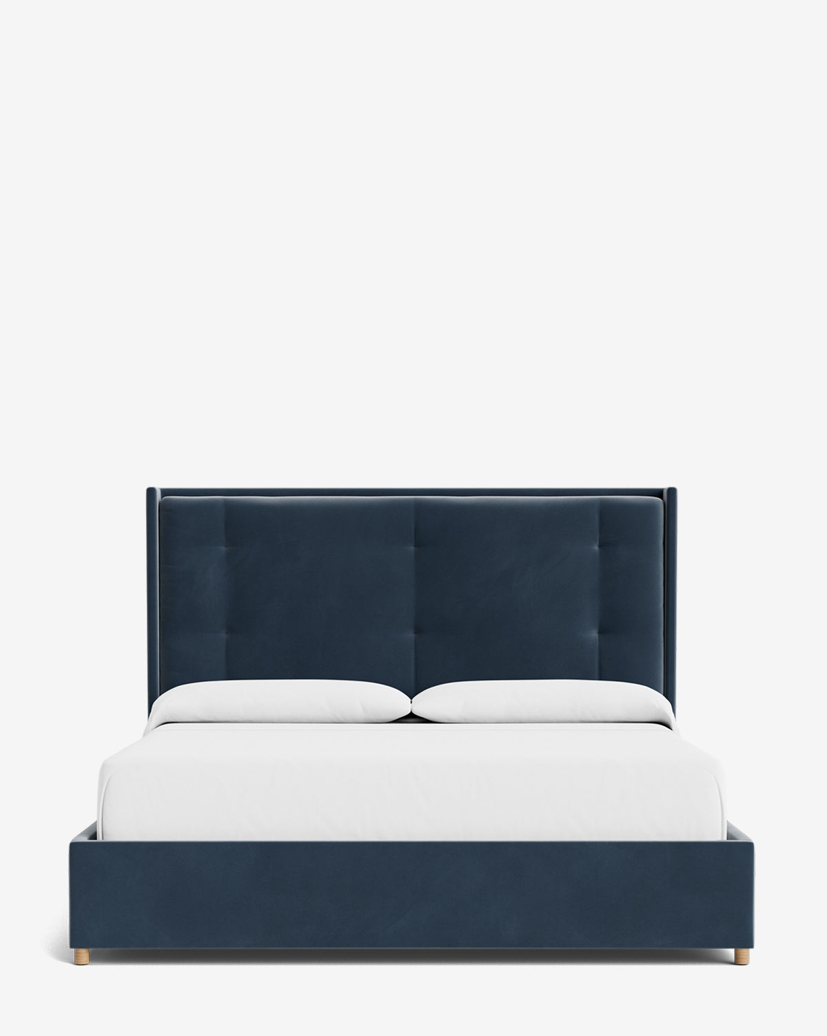 The Ria Bed is a modern king-size upholstered bed with a customizable dark blue tufted headboard, two white pillows, and white bedding, all set against a plain white background by McGee & Co.