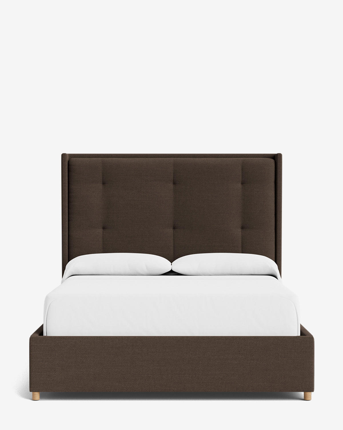 The Ria Bed is a modern upholstered bed with a dark brown frame and tall, tufted headboard. Shown with white bedding and two pillows against a plain white background, this piece is customizable to suit your style by McGee & Co.