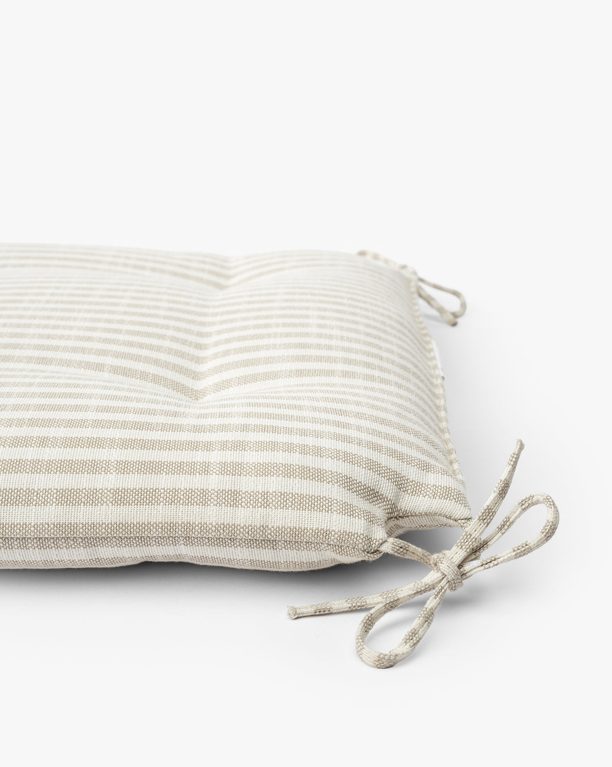 The Credence Romany Counter Stool Cushion features beige and white linen stripes, tufted details, and fabric corner ties to fit your stool, shown on a white background. McGee & Co.