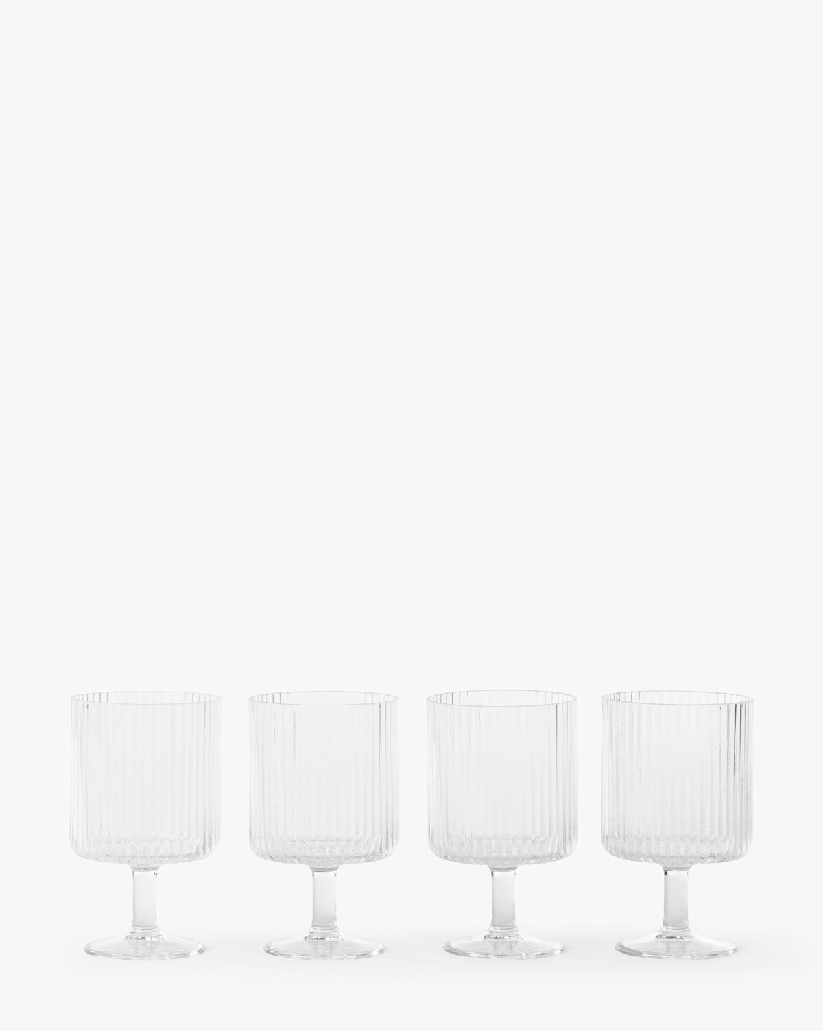 The Sanibel Acrylic Goblets (Set of 4) feature clear, ribbed designs and short stems, arranged in a row against a white background—ideal for outdoor table settings with their elegant, durable style.