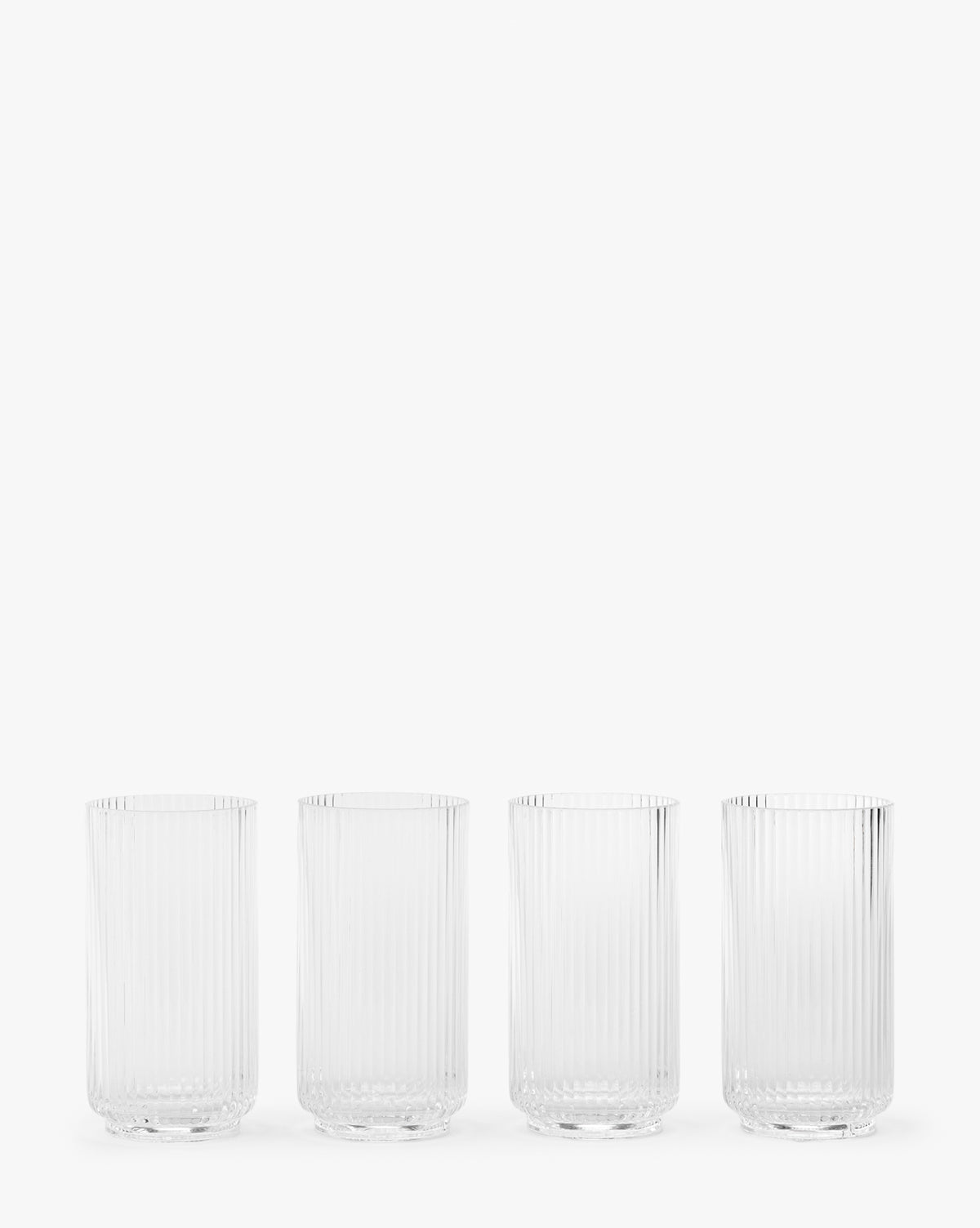 The Sanibel Acrylic Highball Drinking Glasses (Set of 4) feature vertical ribbed patterns and are arranged in a row against a plain white background, making them perfect for elegant outdoor table settings, by McGee & Co.