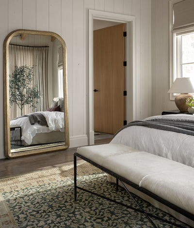 A stunning floor mirror enhancing the elegance of a bedroom.
