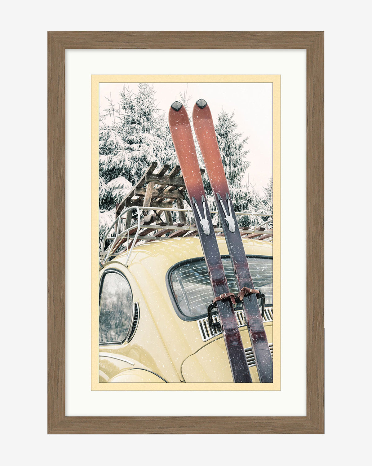 The Ski Buggy is a framed photo art piece featuring vintage red skis attached to a yellow car parked before snow-covered pine trees in winter, all set in a stylish wood frame, by McGee & Co.