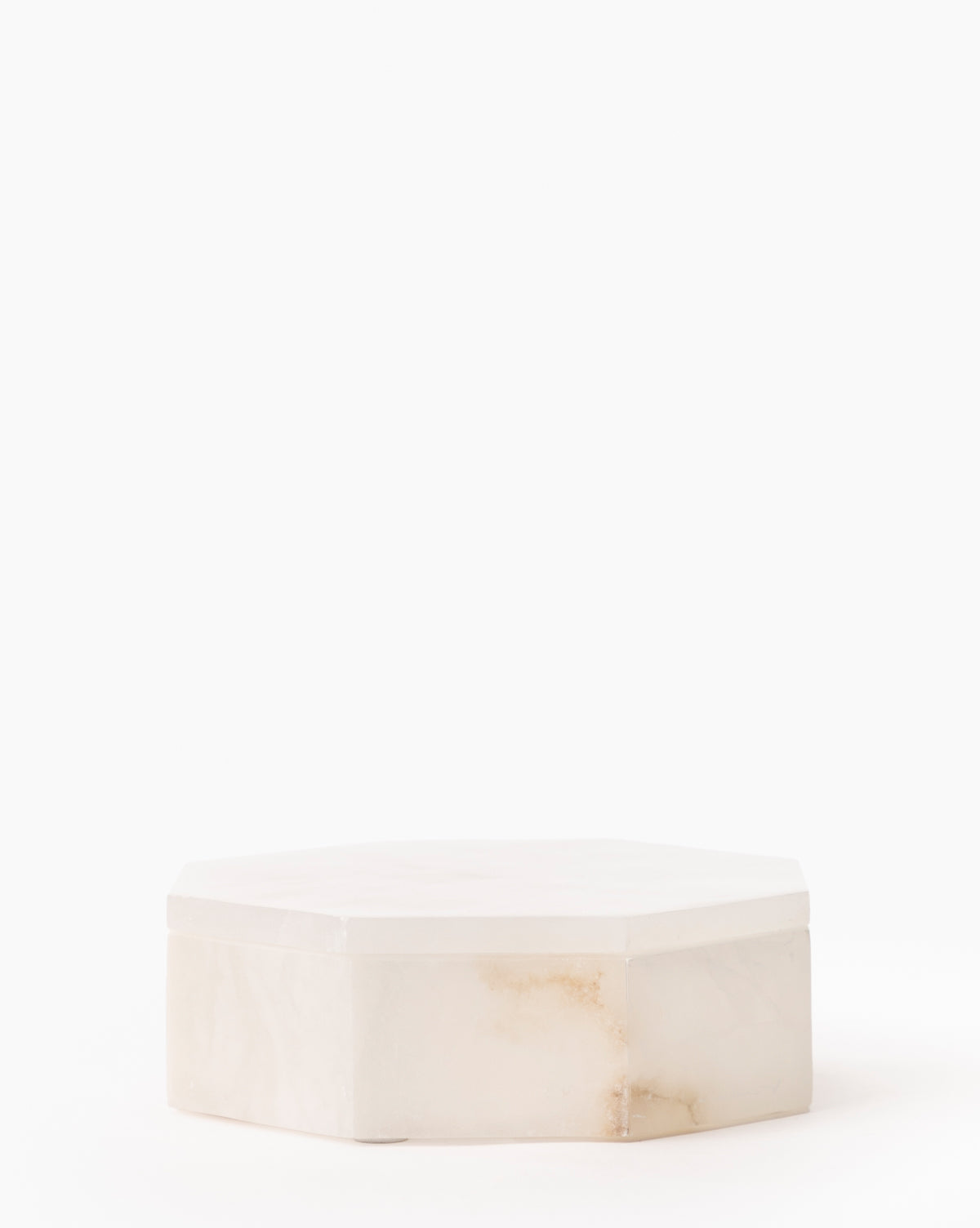 The Sonya Alabaster Box features an elegant hexagonal design in white marble with subtle brown veining, displayed on a plain white background.