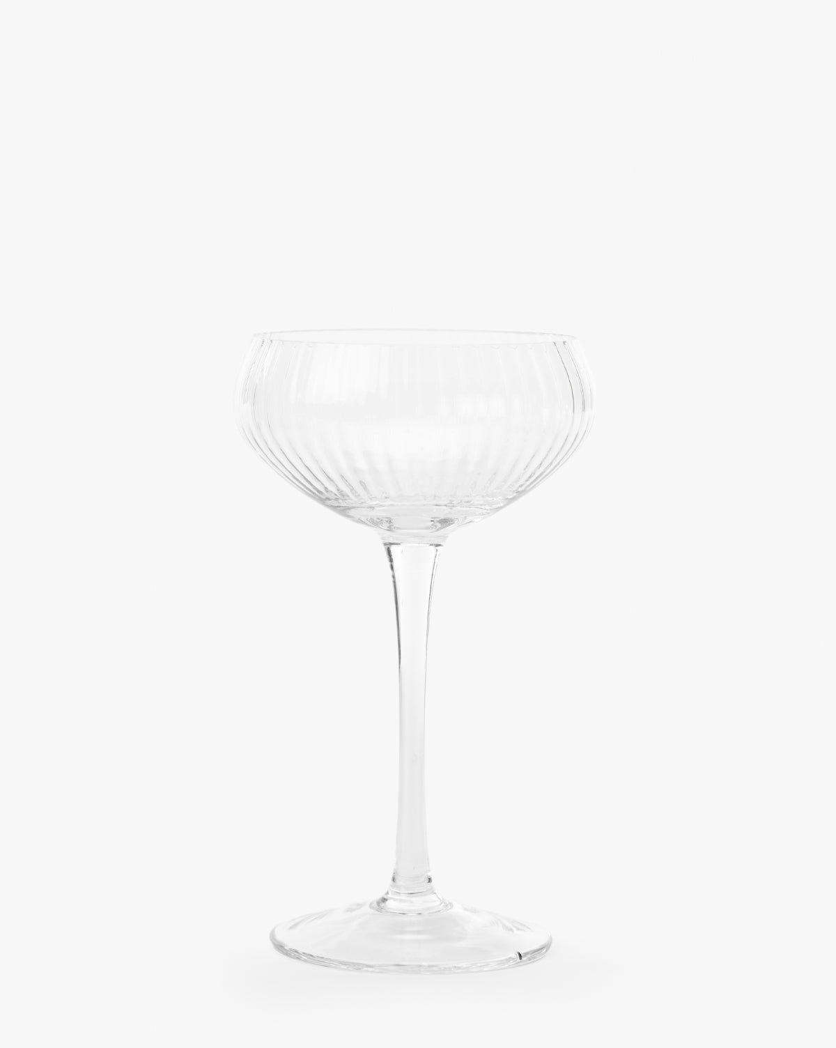 The Stemmed Champagne Glass features a clear, ribbed design with a wide bowl and long stem, embodying elegant glassware against a plain white background, by McGee & Co.
