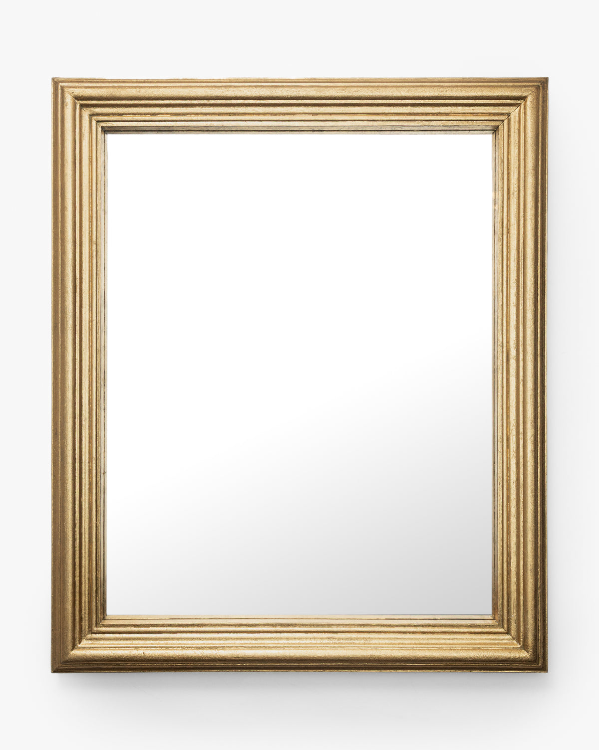 The Suzanne Wall Mirror showcases a square, gold leaf textured ridged frame. Its clear surface reflects a minimalist setting, making it an elegant accent against a plain white background by McGee & Co.