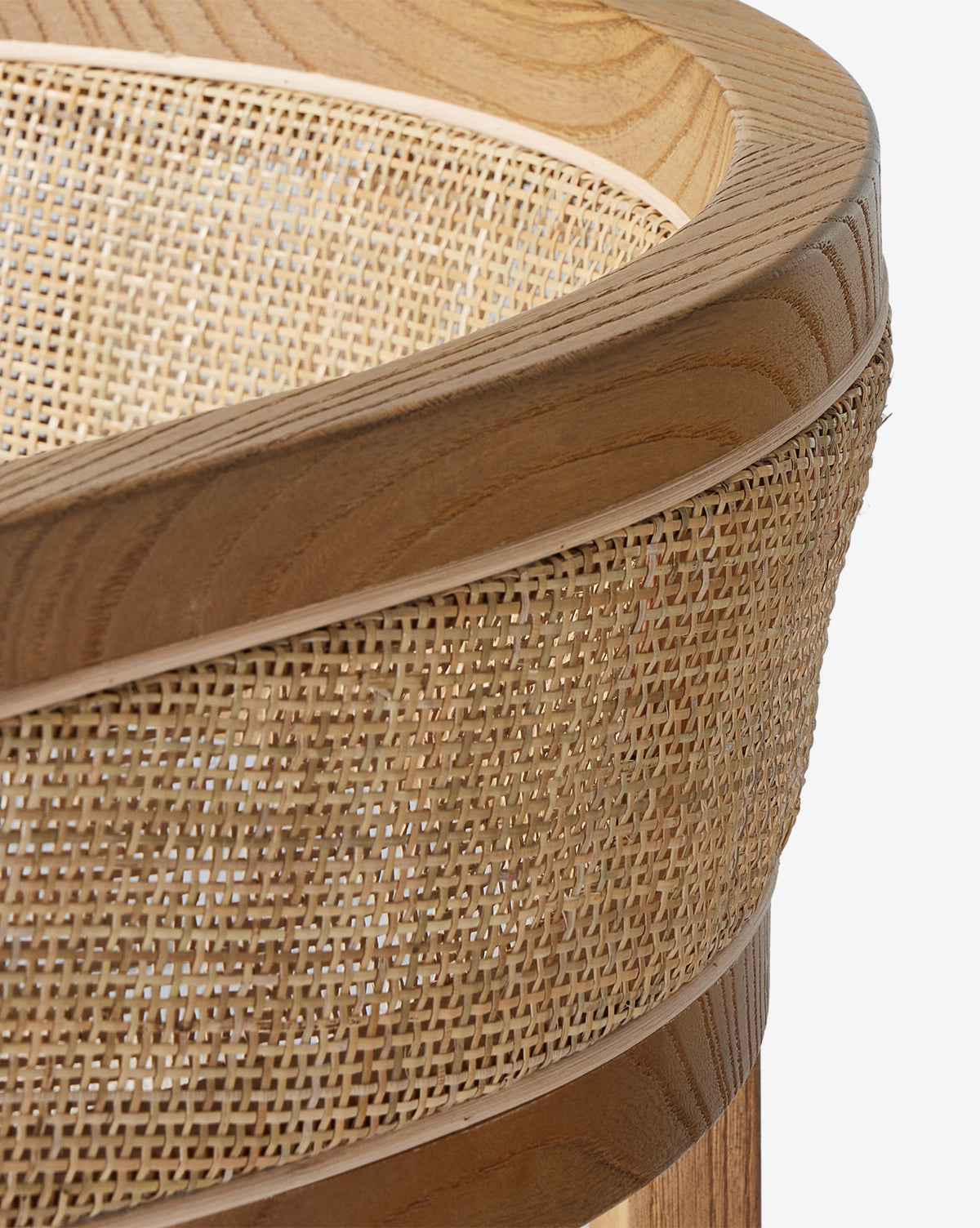 Close-up of the Valissa Dining Armchair with a curved wooden frame and woven cane seatback, showcasing natural wood grain and intricate texture for an elegant, modern design, by McGee & Co.