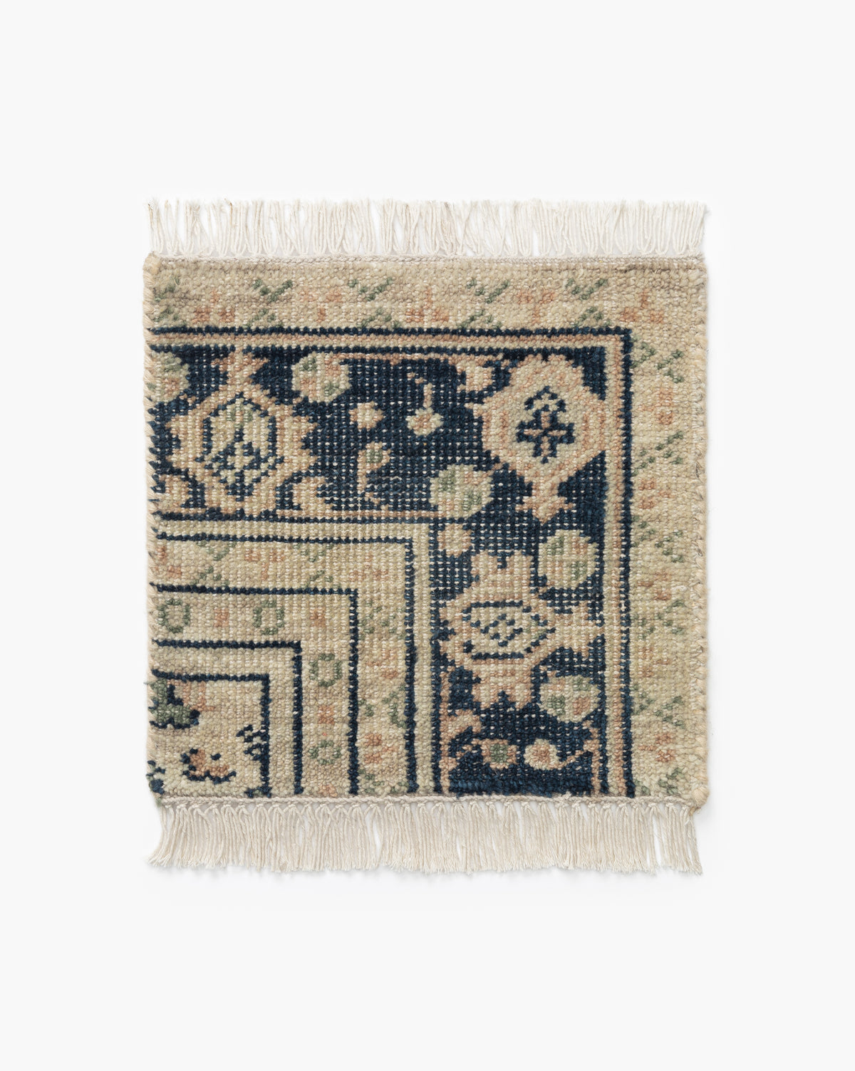 The Vercelli Hand-Knotted Wool Rug Swatch is a rectangular woven sample with fringed edges, showcasing navy blue and beige geometric and floral motifs on a white background, bordered and cornered with traditional patterns, by McGee & Co.