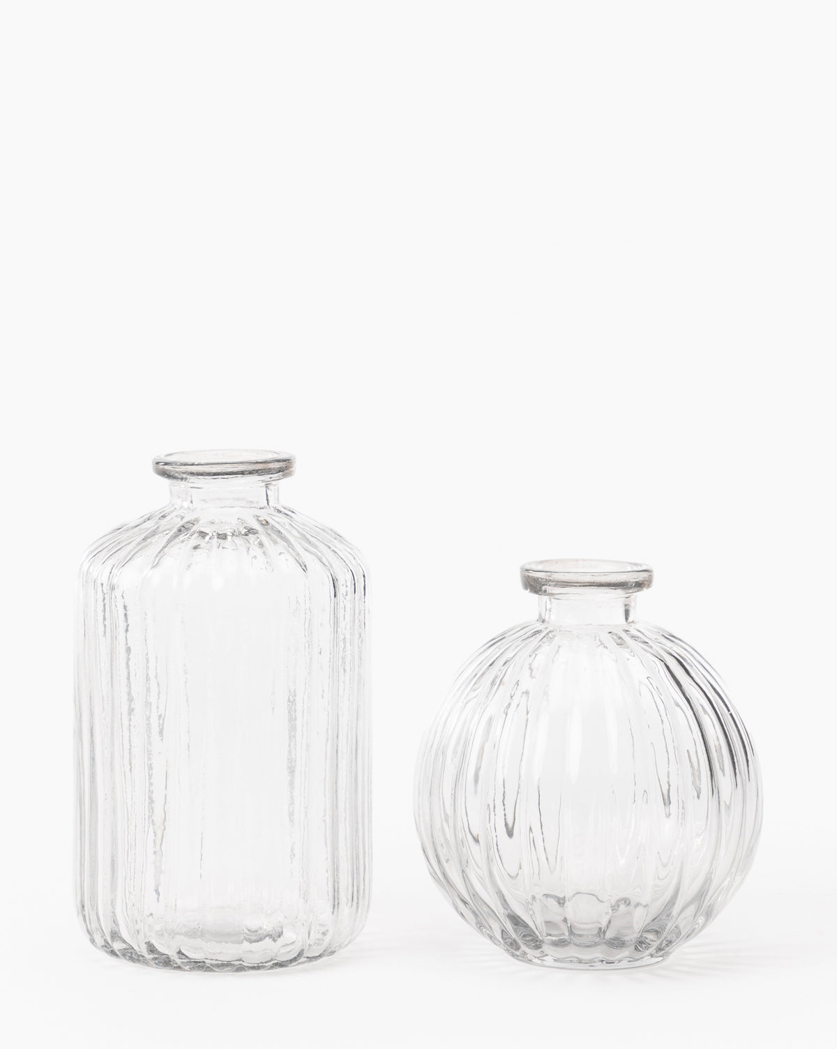 Two clear mouth-blown Verlice Glass Cylinder Vases with vertical ribbing—a tall cylinder vase on the left and a shorter, round vase on the right—both with narrow openings, set against a white background.