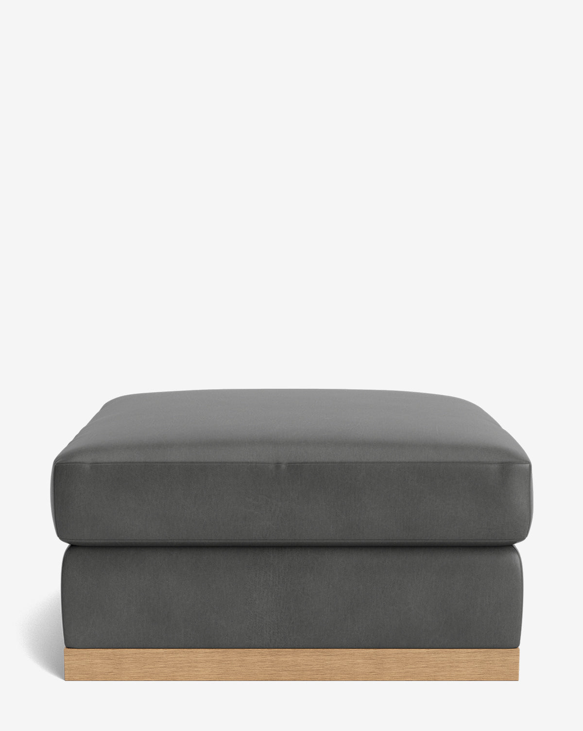 The Vernon Modular Ottoman features a rectangular shape with dark gray velvet upholstery, a soft cushioned top, and a light wooden base, displayed against a plain white background by McGee & Co.