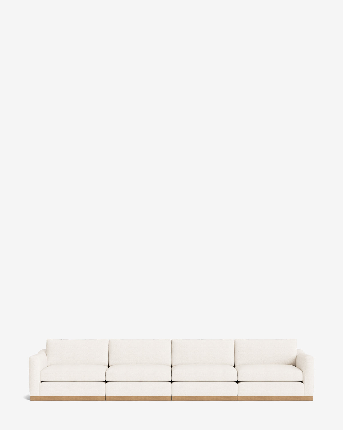 The Vernon Modular Sofa (121-157) is a modern, long white sofa with four seat cushions and a light wooden base, shown against a plain white background by McGee & Co.