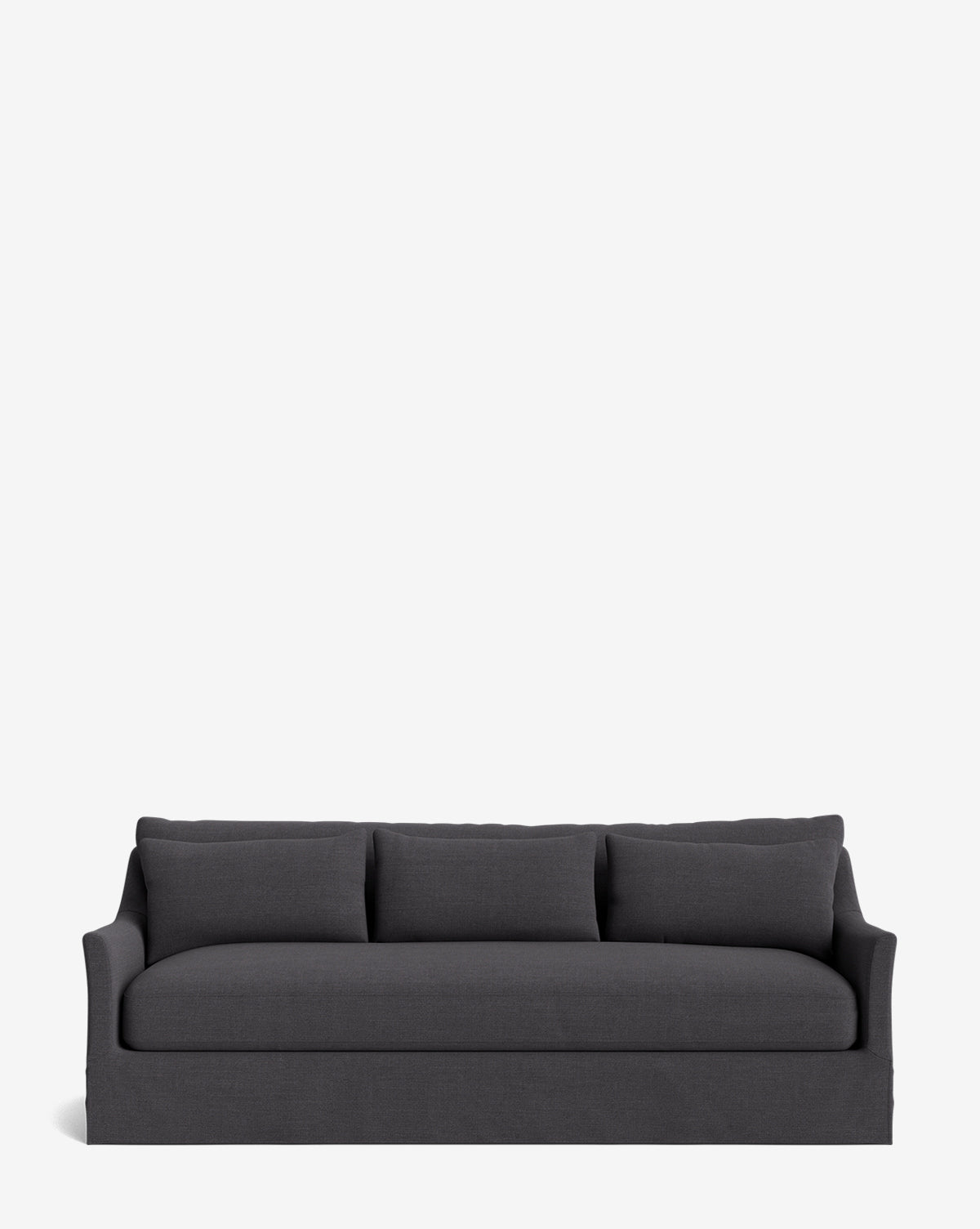 The Wilhelmina Deep Slipcover Sofa (85-110) in dark gray features three back cushions and a soft, upholstered skirt, providing a luxurious seat set against a plain white background, by McGee & Co.