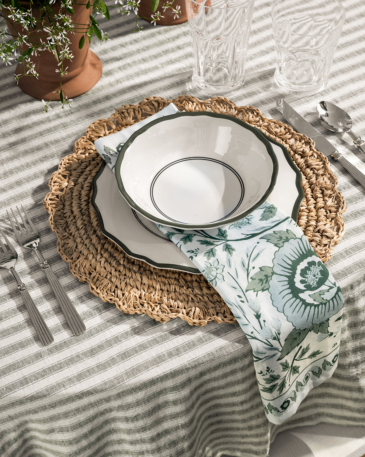 Striped green and white 100% linen tablecloth shown with place settings from McGee & Co.