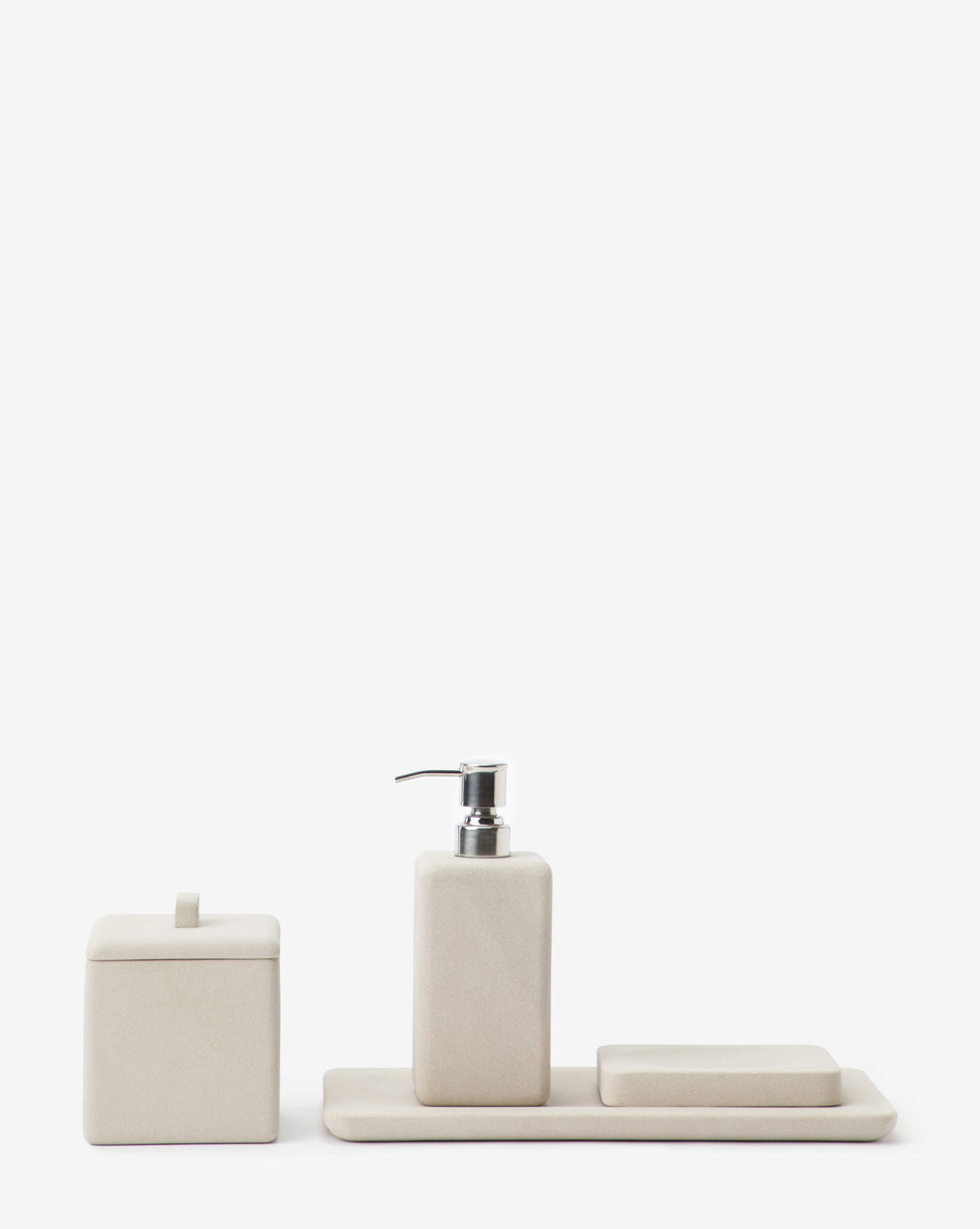 The Amada Sandstone Bath Collections minimalist beige set brings an organic look with a soap dispenser, rectangular tray, soap dish, and lidded container—ideal for enhancing your bathroom decor.