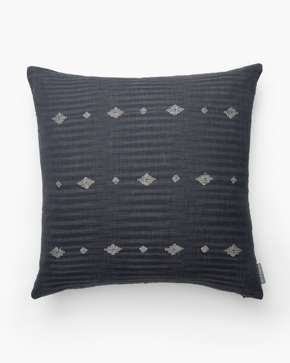 The Atilla Pillow Cover, crafted from navy linen cotton, showcases subtle horizontal stripes and small, evenly spaced silver geometric embroidery, set against a white background, by McGee & Co.