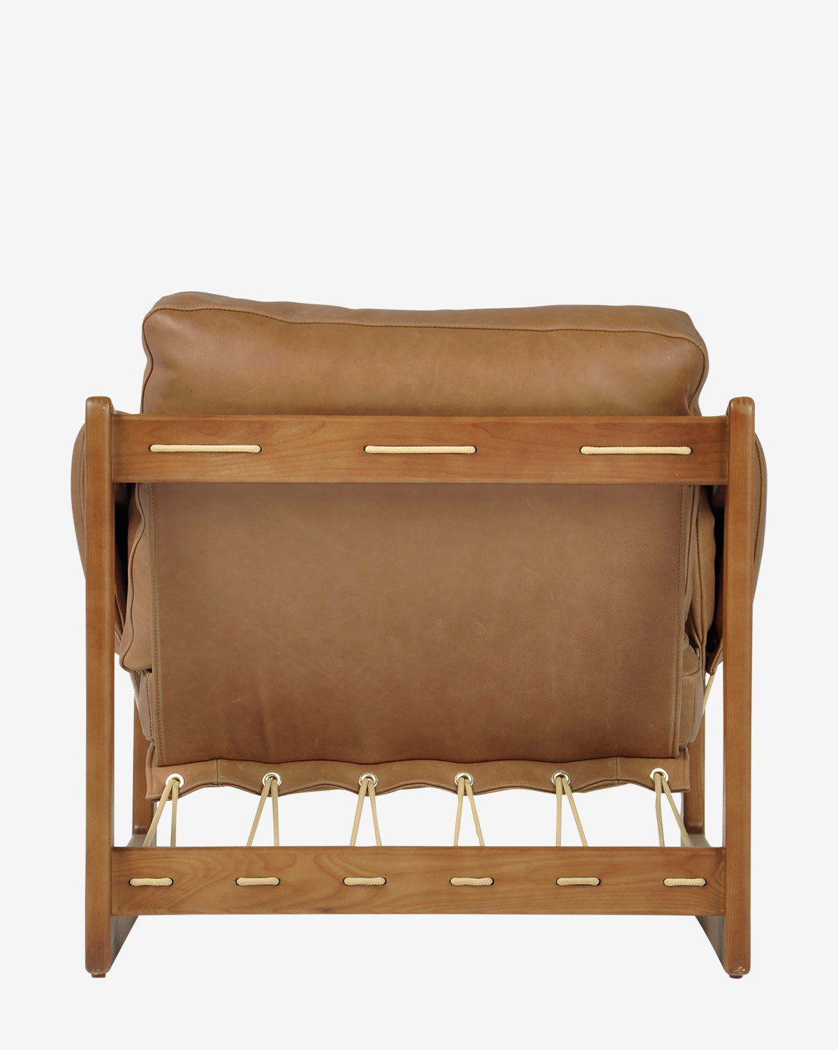 The Barker Lounge Chair, shown from the back in tan top-grain leather with a wooden frame and gold accents, features visible joints that capture the refined elegance of midcentury sling seating, by McGee & Co.