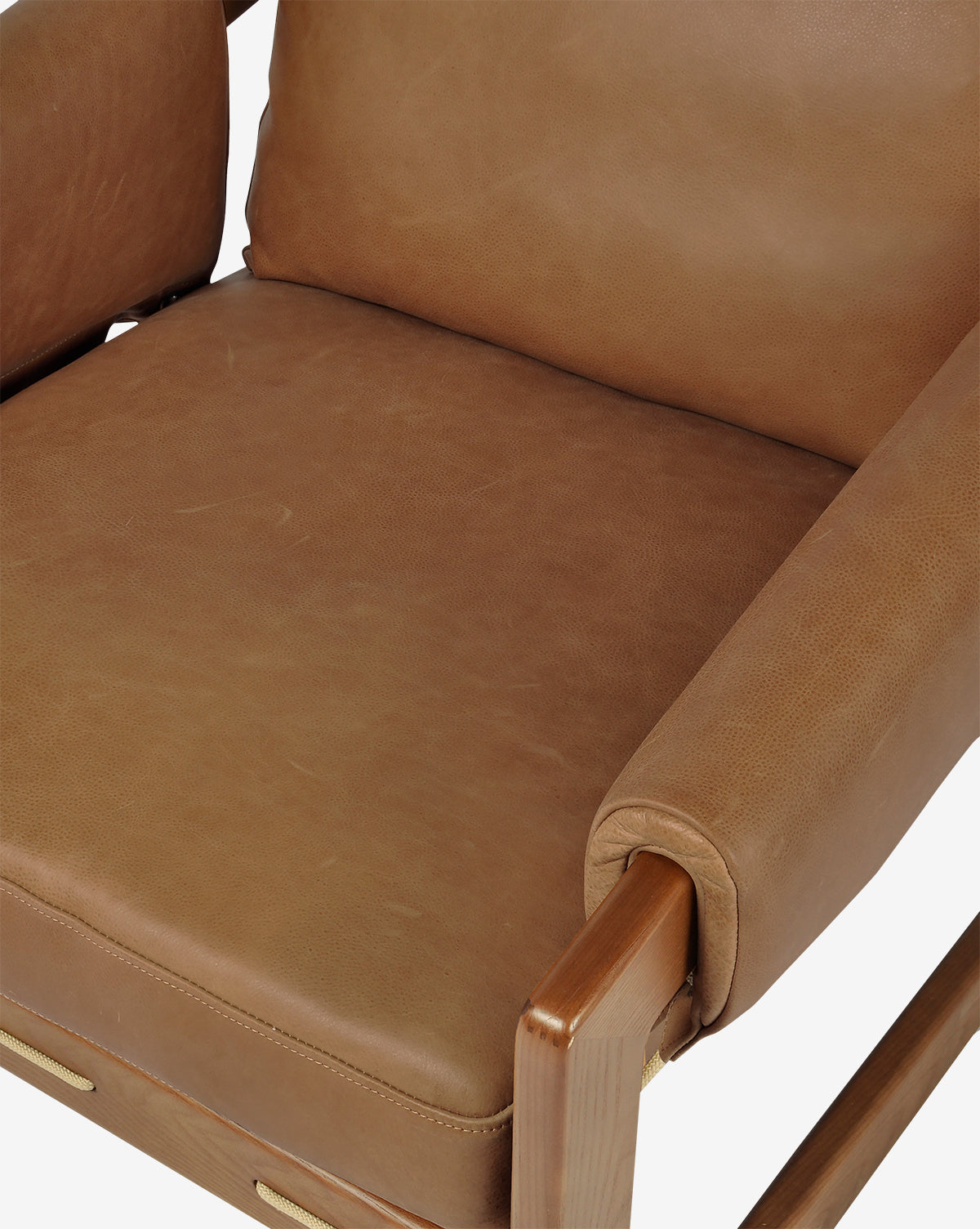 Close-up of the Barker Lounge Chair in top-grain leather with wooden armrests and frame, focusing on the seat, cushion, and backrest against a white background by McGee & Co.