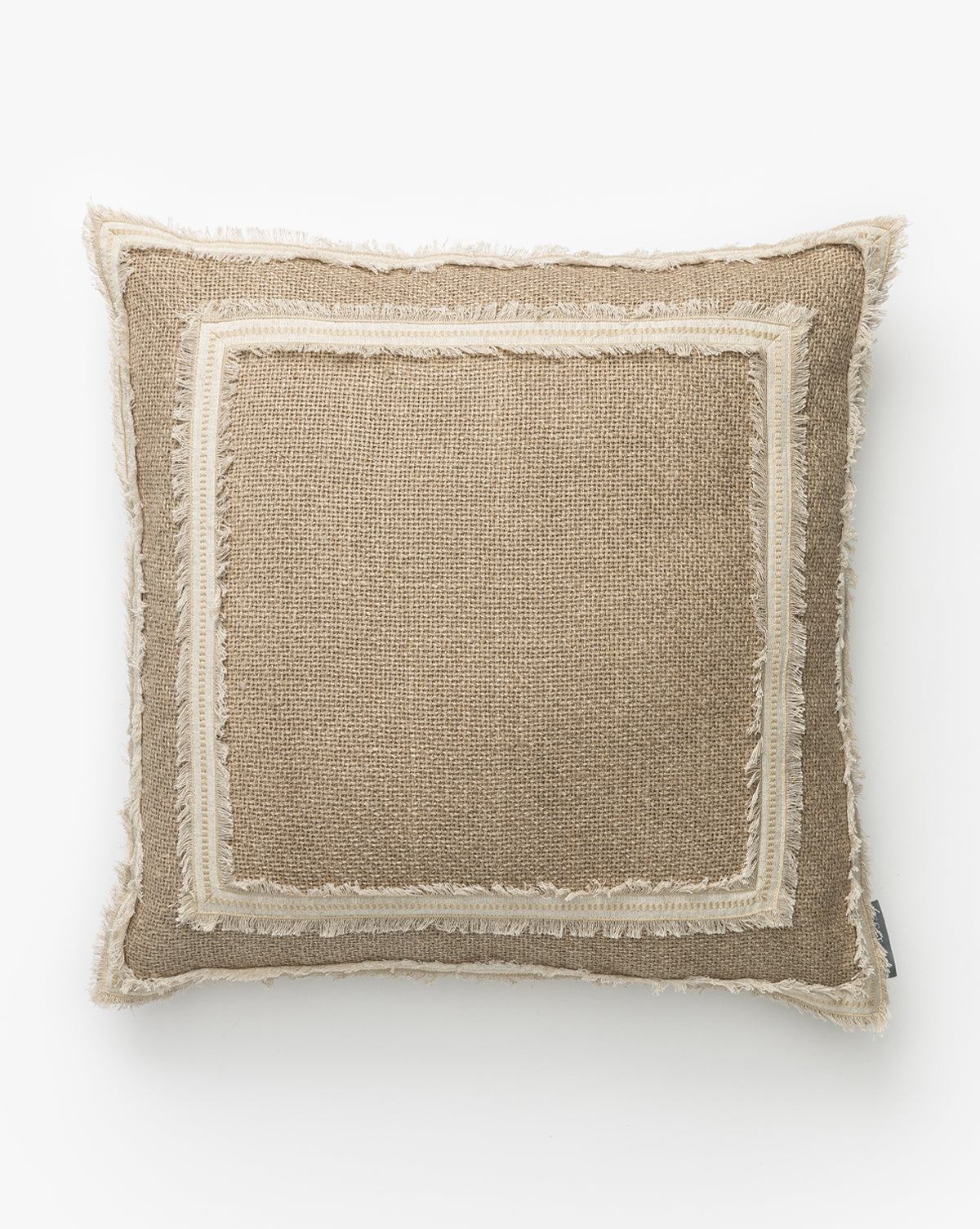 The Cameron Pillow Cover features a square shape with textured beige fabric, a lighter double-fringed and inner border, subtle rustic style, and a small fabric tag on one side for a neutral, layered look by McGee & Co.