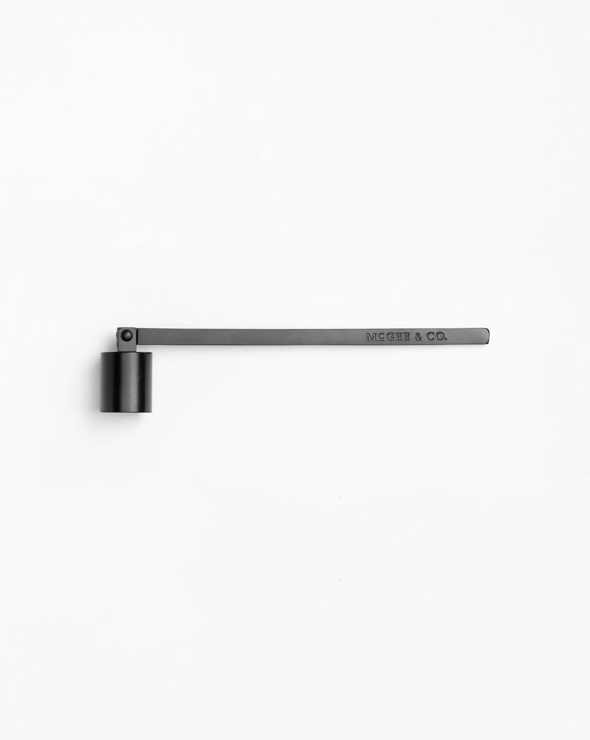 The Candle Snuffer, made of black metal with a cylindrical cap and long, straight handle engraved with MCGHEE & CO., adds an elegant touch to any space. Shown on a plain white background.