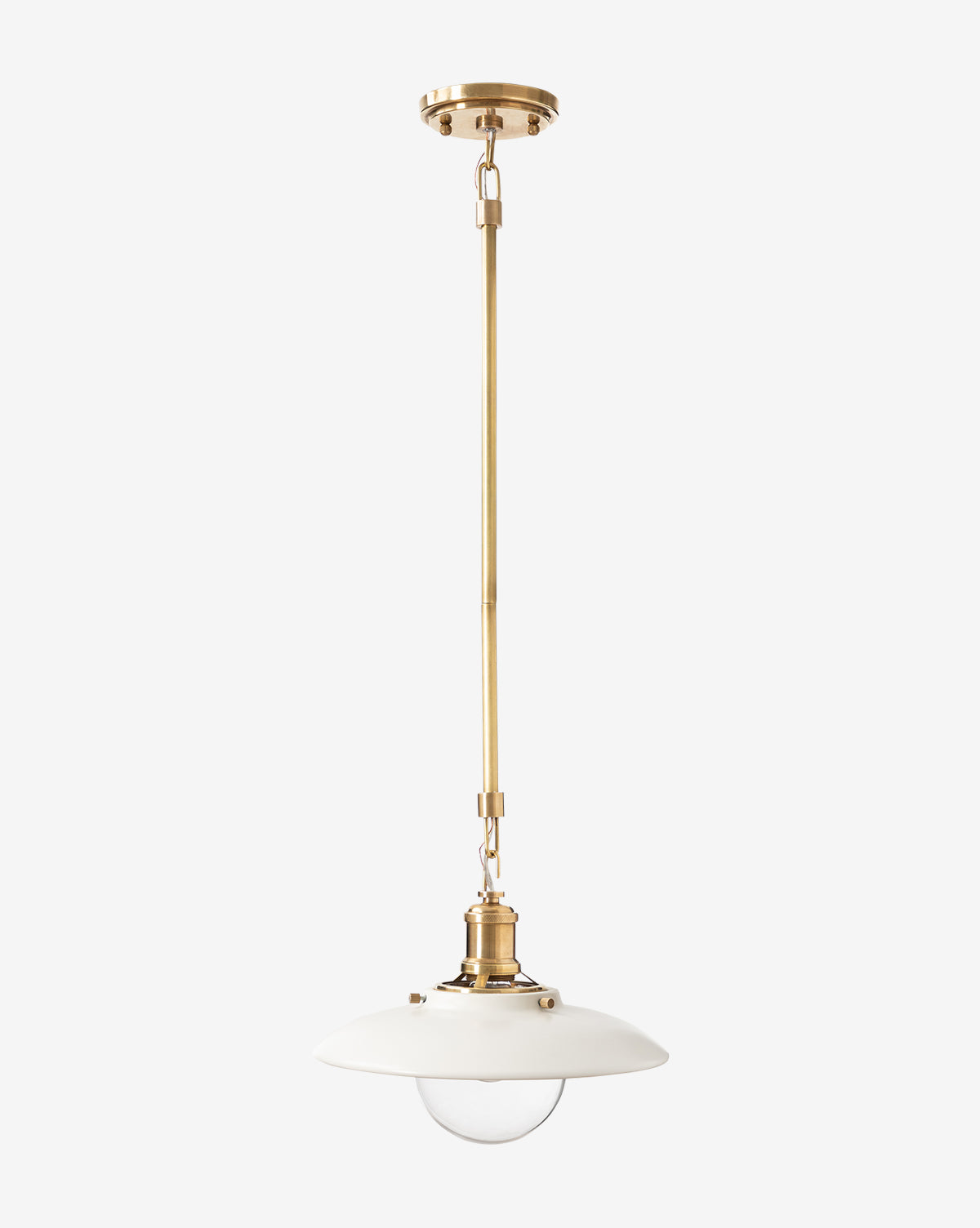 The Didier Ceramic Pendant features an antique brass rod, white round ceramic shade, and exposed glass bulb, hanging from a brass ceiling mount against a plain background, by McGee & Co.