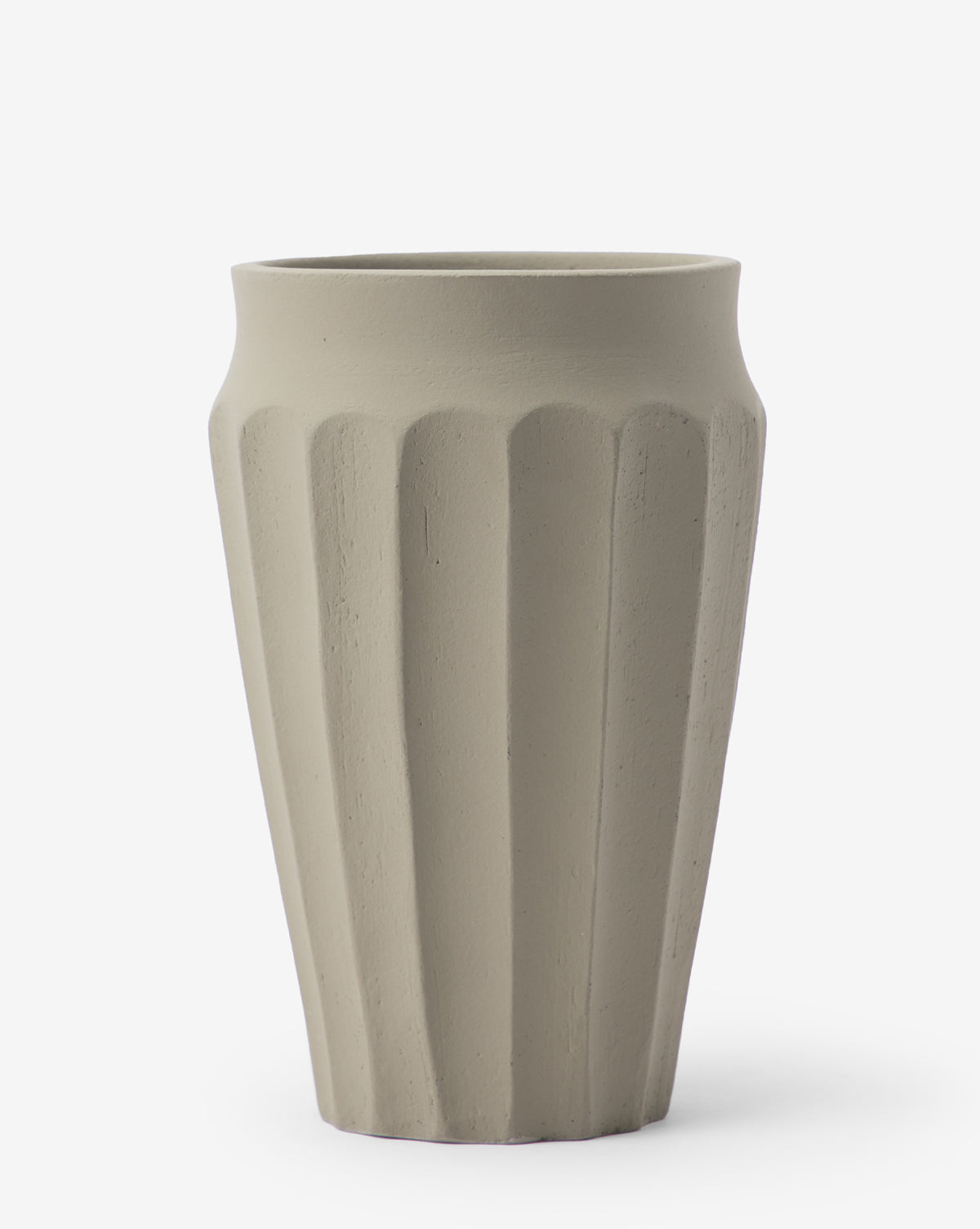 The Frida Vase is a tall, beige ceramic piece with a matte finish and vertical fluted ridges. Hand-glazed for a modern look, it stands out against a plain white background.