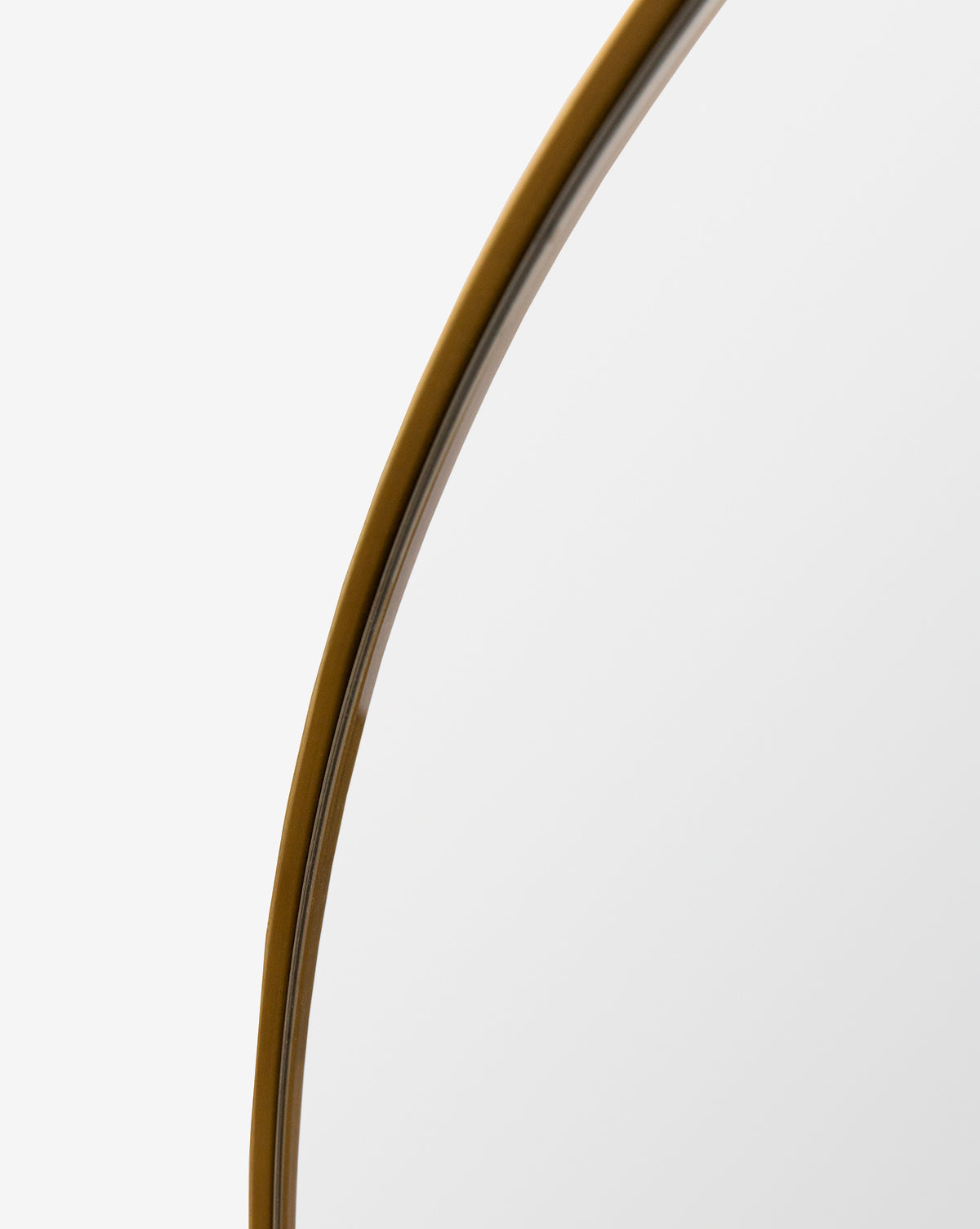 A detailed look at the Jace Inset Circle Mirrors thin gold metal frame, set against a plain white background, by McGee & Co.