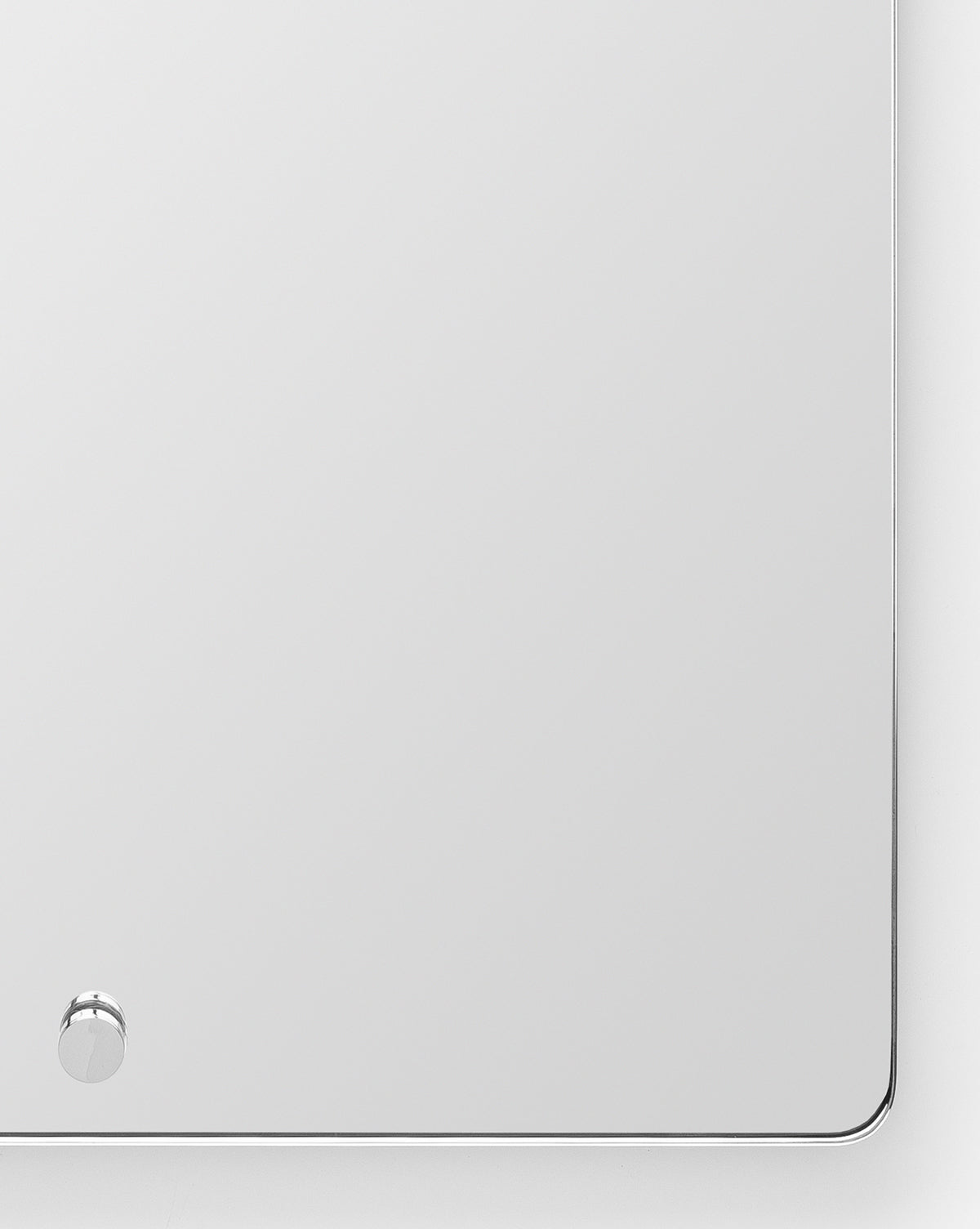 The Jacob Rectangular Mirror has rounded corners, a slim brass frame, and a small round knob at the lower left. Ideal for entryways, it features a clean design and beautifully reflects its surroundings by McGee & Co.