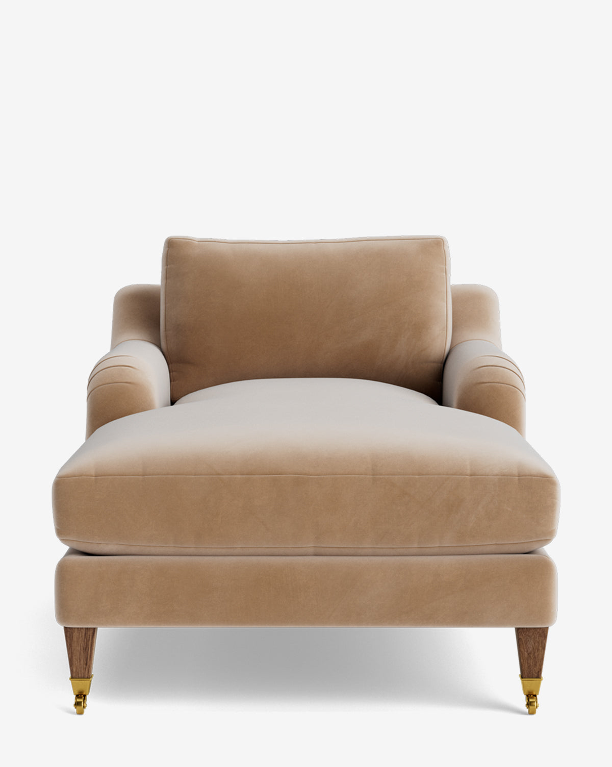 The Lucille English Roll Arm Chaise Lounge features tan velvet upholstery, wooden legs with brass caster wheels, and a plush down-wrapped cushion with a matching backrest pillow, shown from the front against a white background by McGee & Co.