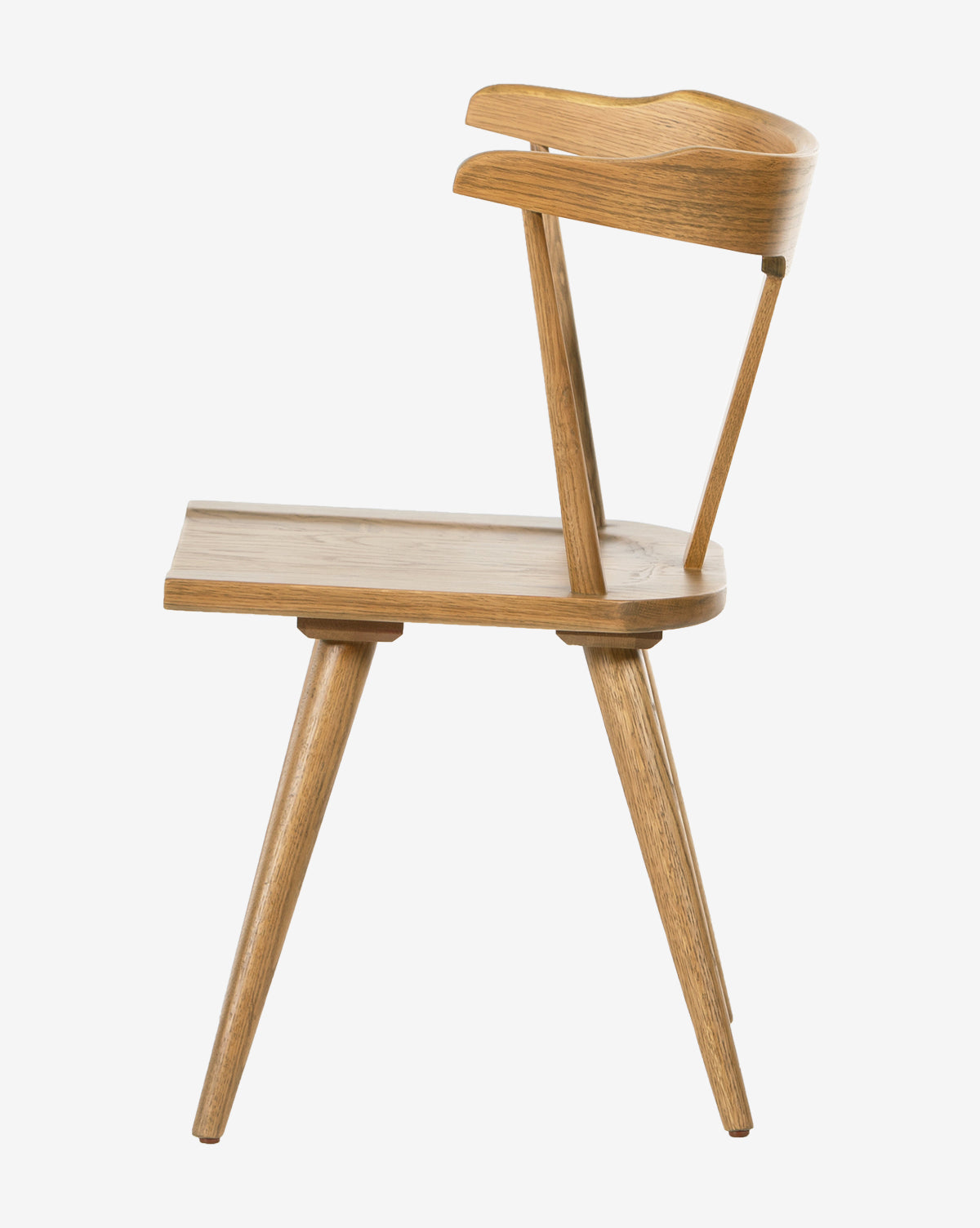 Side view of the Ruthie Dining Chair, crafted from light solid oak with a wide seat, angled legs, and a curved minimalist backrest. Its simple lines showcase a modern, contemporary design.