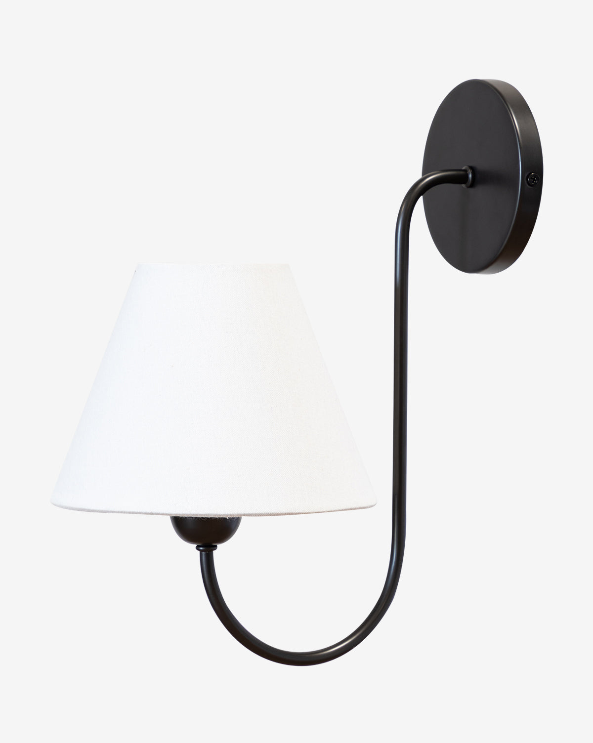 The Makerspalm Wainwright Single Swoop Sconce is a black, wall-mounted light with a curved arm and a white linen shade, shown against a plain white background. McGee & Co.