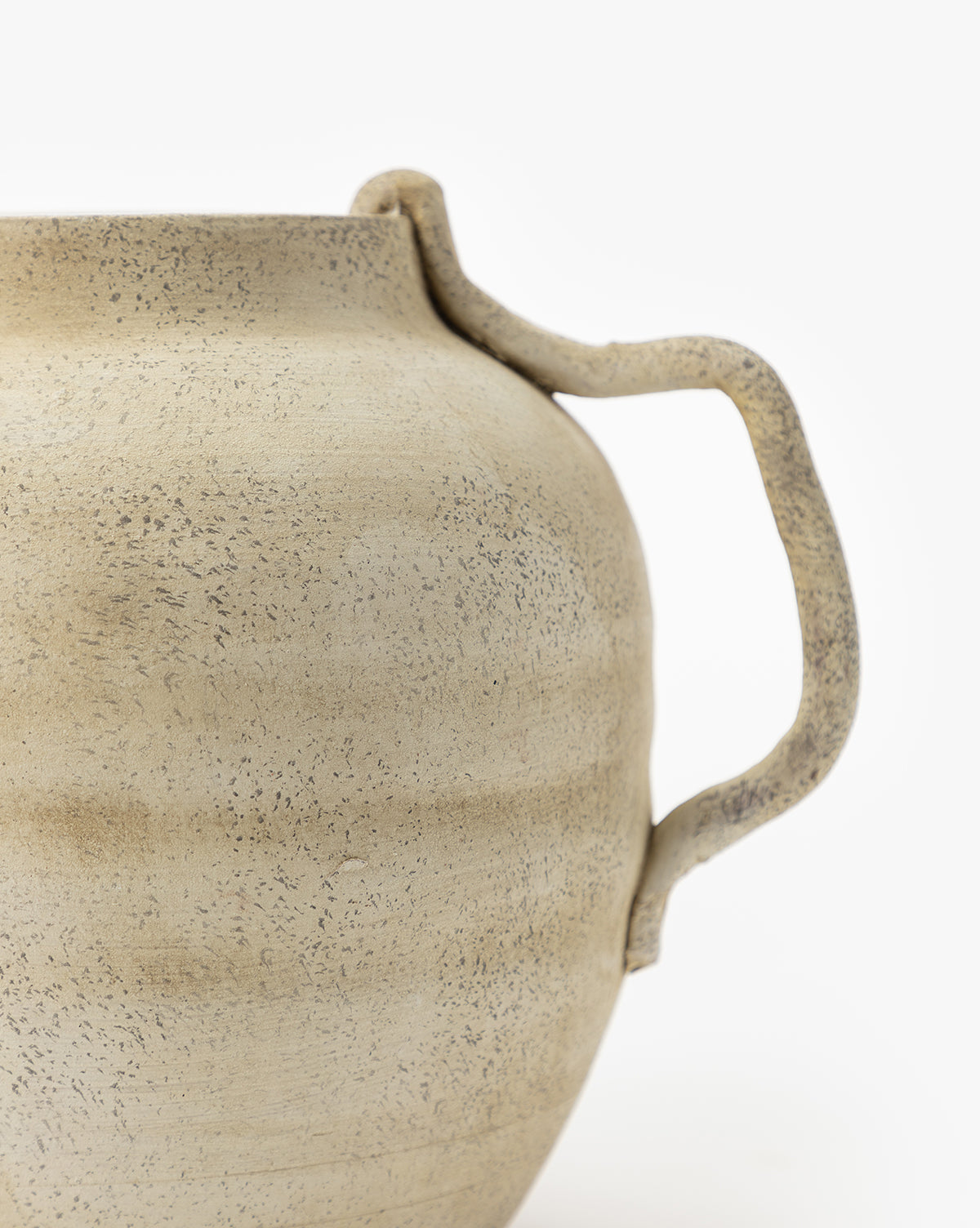 Close-up of the Weathered Ceramic Jug, featuring a textured, light beige finish with a single curved handle. Its speckled, slightly uneven surface and handcrafted details evoke a vintage style against a white background.
