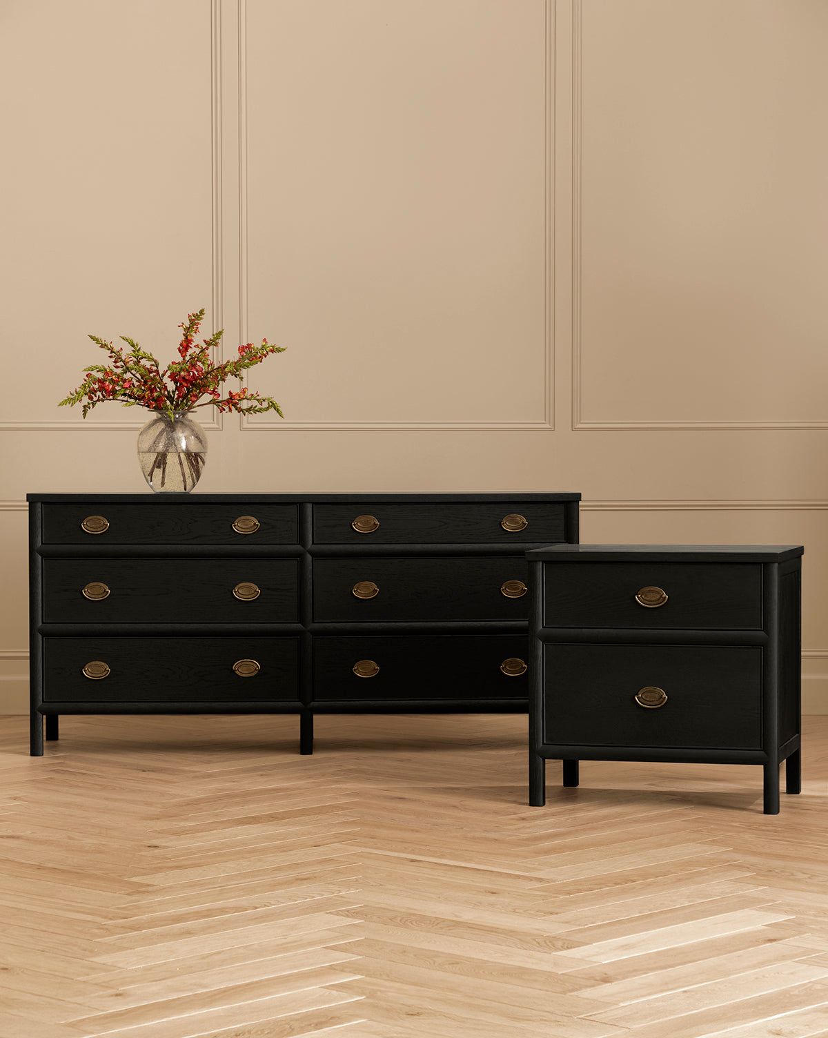 The Edward Dresser, finished in sleek black ash with six drawers and round brass handles, offers elegant bedroom storage. Pair it with the matching nightstand and top with a glass vase of red flowers for a vibrant accent by McGee & Co.